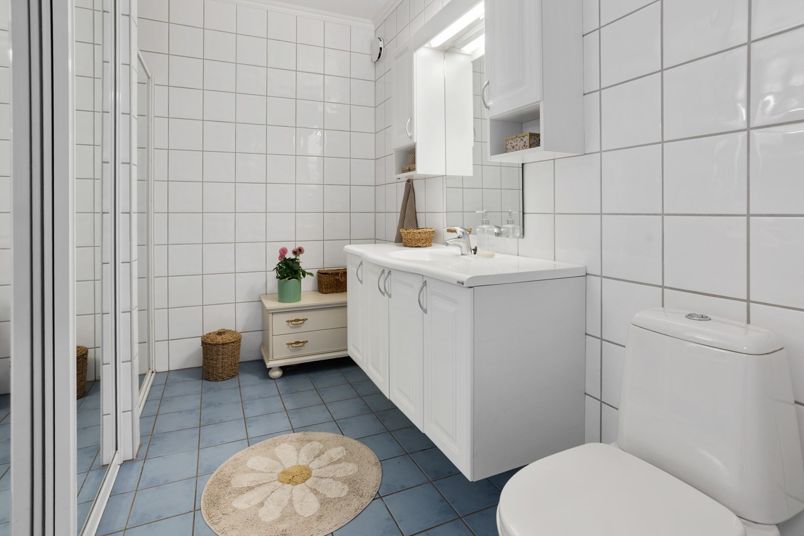 Bad fra 2006 med fliser på vegg og gulv. Badet er innredet med nedfelt servant i innredning, gulvstående toalett, dusjnisje opplegg for vaskemaskin. Varmekabler. Galleribilde