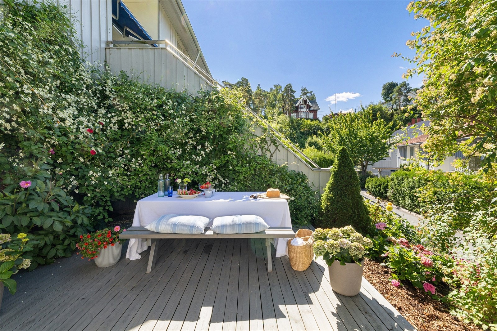 Sjarmerende og solrik terrasse omgitt av vakker beplantning Galleribilde