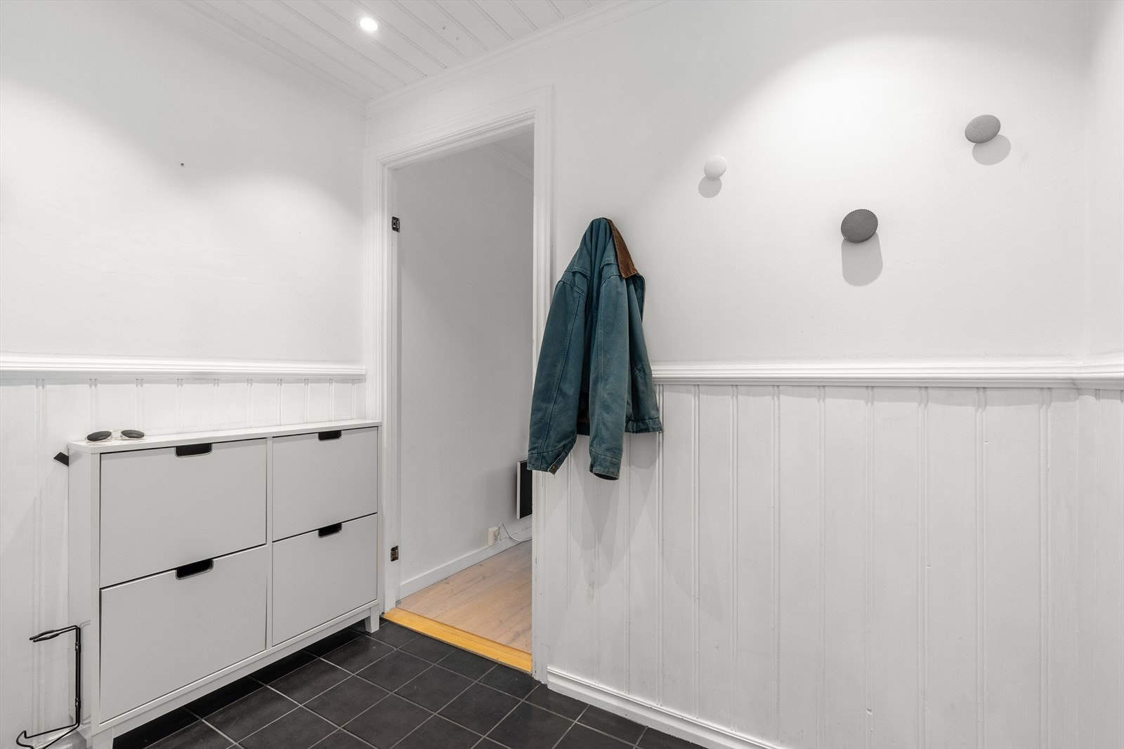 Praktisk entré med malt brystpanel og plass til skotøy og yttertøy. Galleribilde