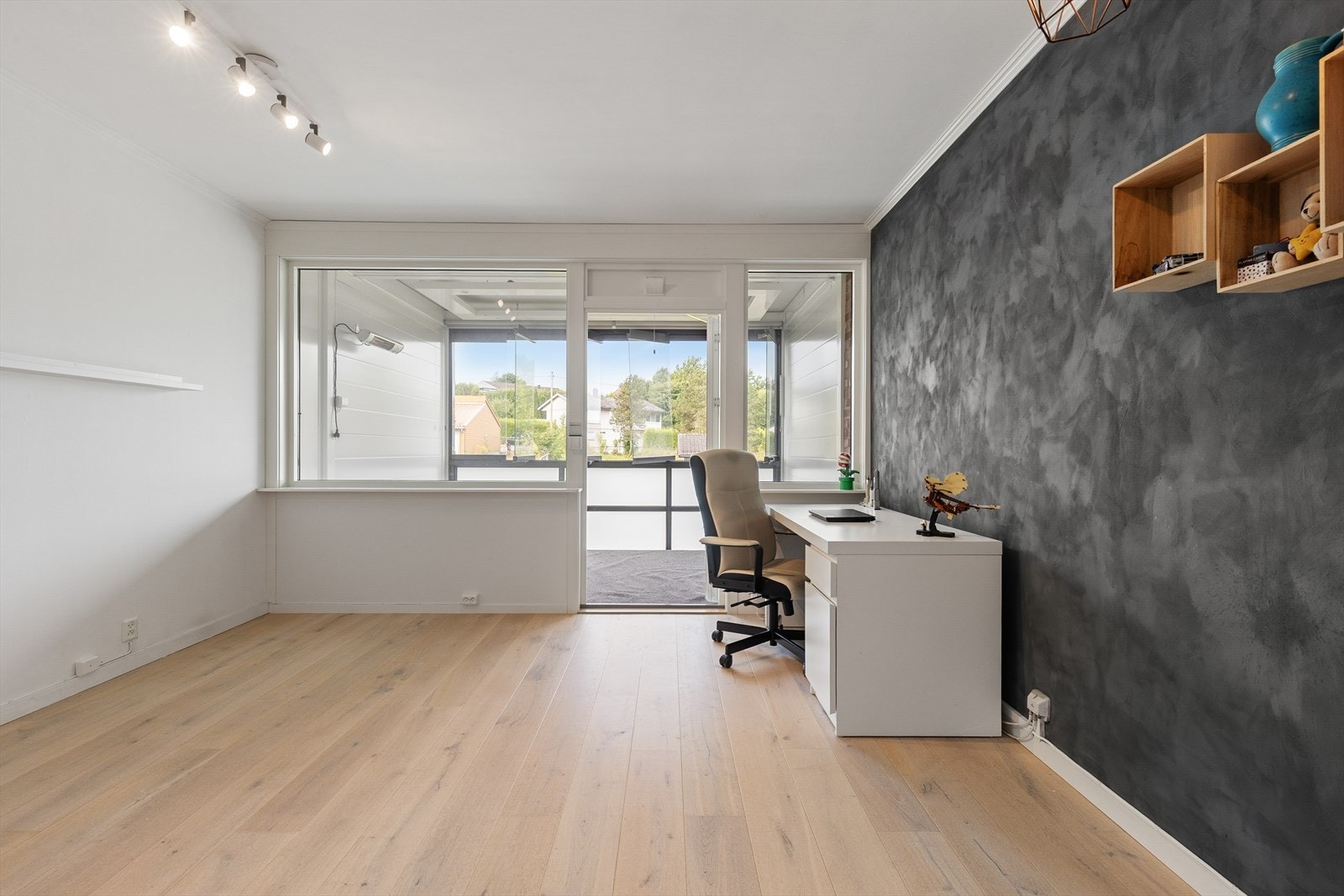 Stuen har laminatgulv og en verandadør fra 2021 som leder ut til balkongen. Galleribilde