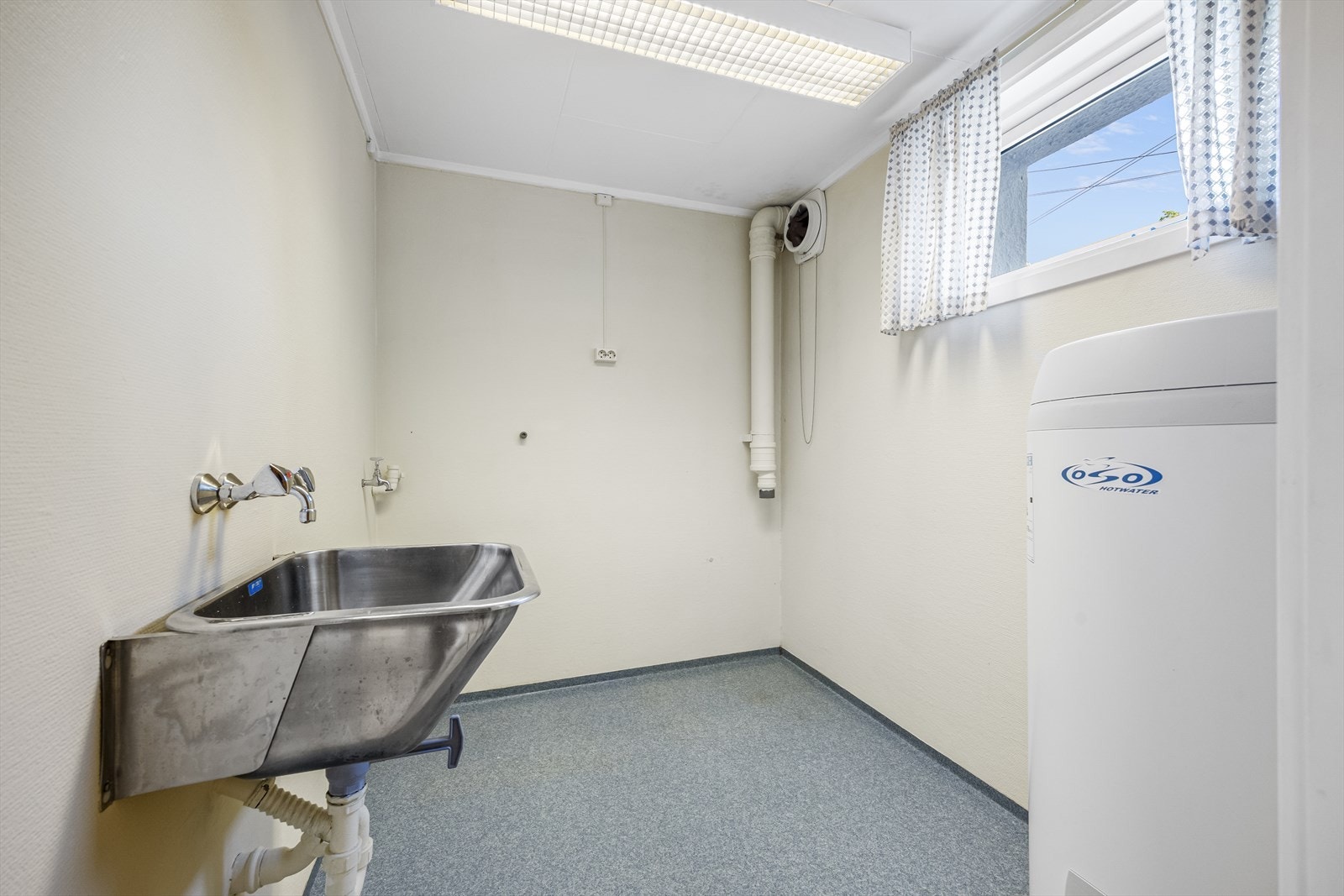 Vaskerom med utslagsvask, bereder og opplegg for vaskemaskin. Galleribilde