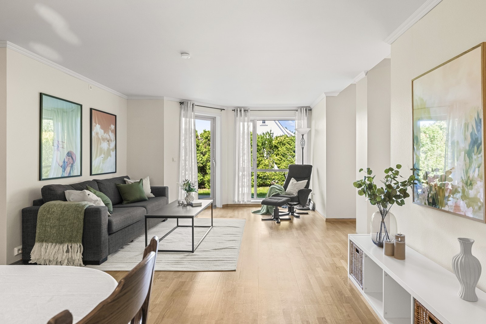 Den lyse stuen har åpen løsning mot kjøkkenet og direkte utgang til en av boligens to uteplasser. Galleribilde