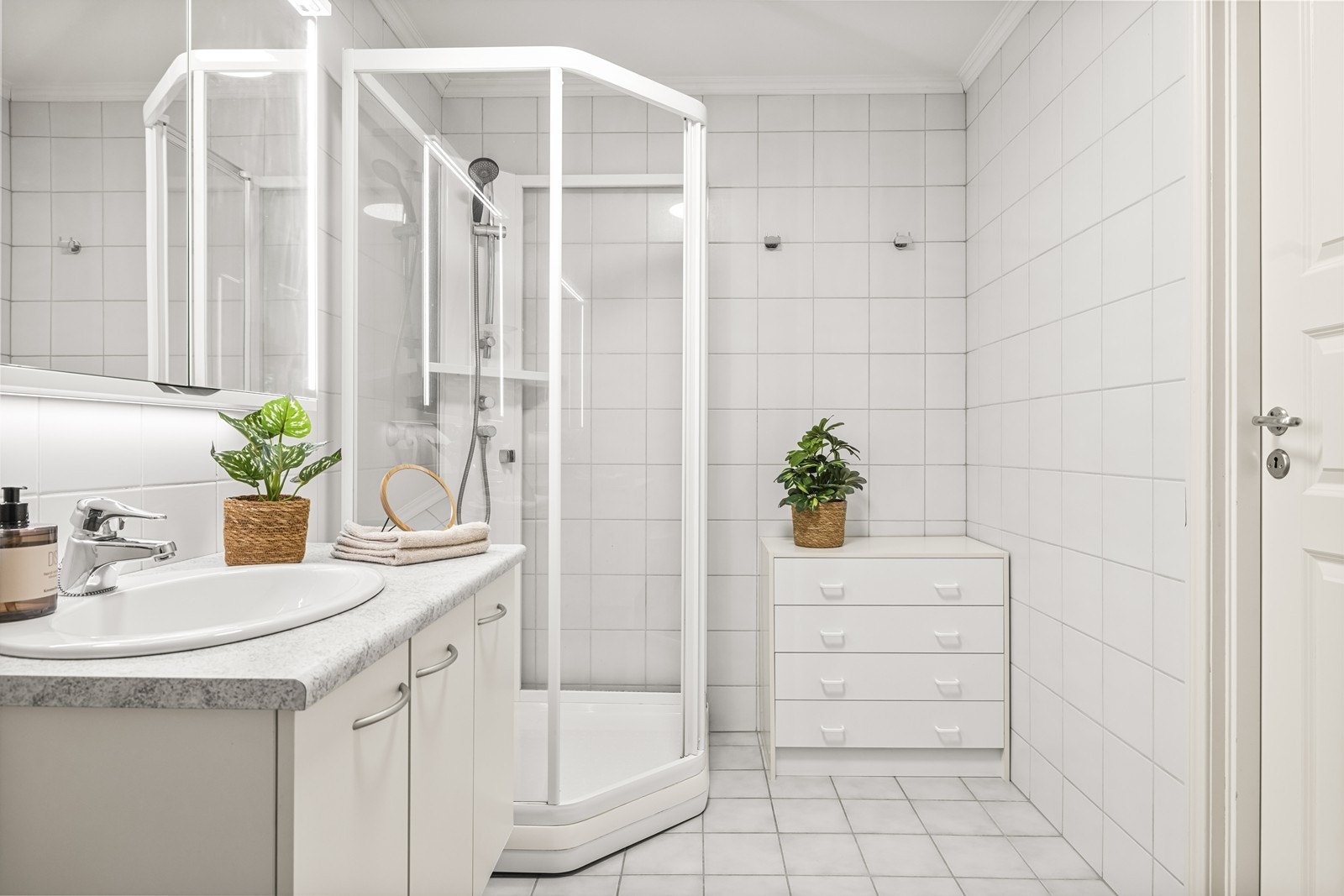 Badet er innredet med servant, toalett og et praktisk dusjkabinett. Galleribilde