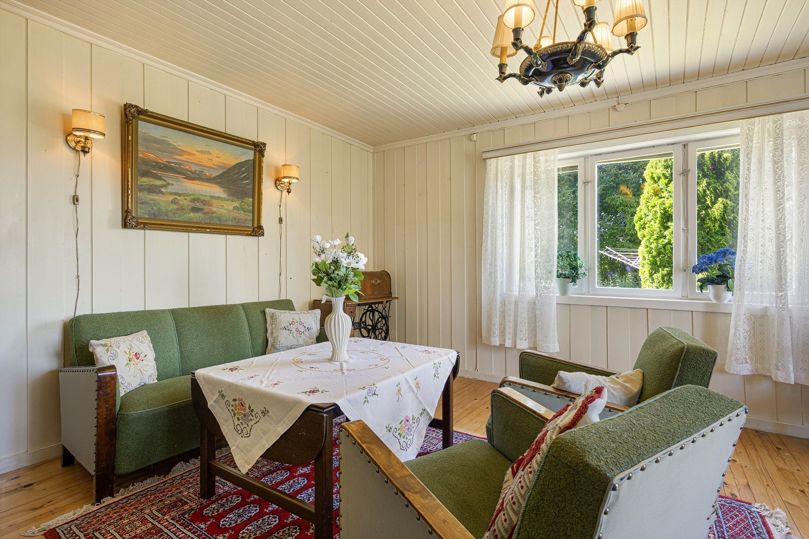 Stuen har panel på veggene og plass til en hyggelig sittegruppe. Galleribilde