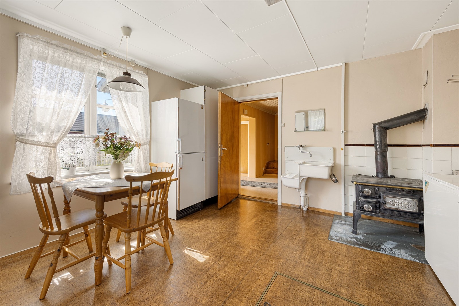 Kjøkkenet har plass til spisebord og er utstyrt med en sjarmerende vedovn. Galleribilde