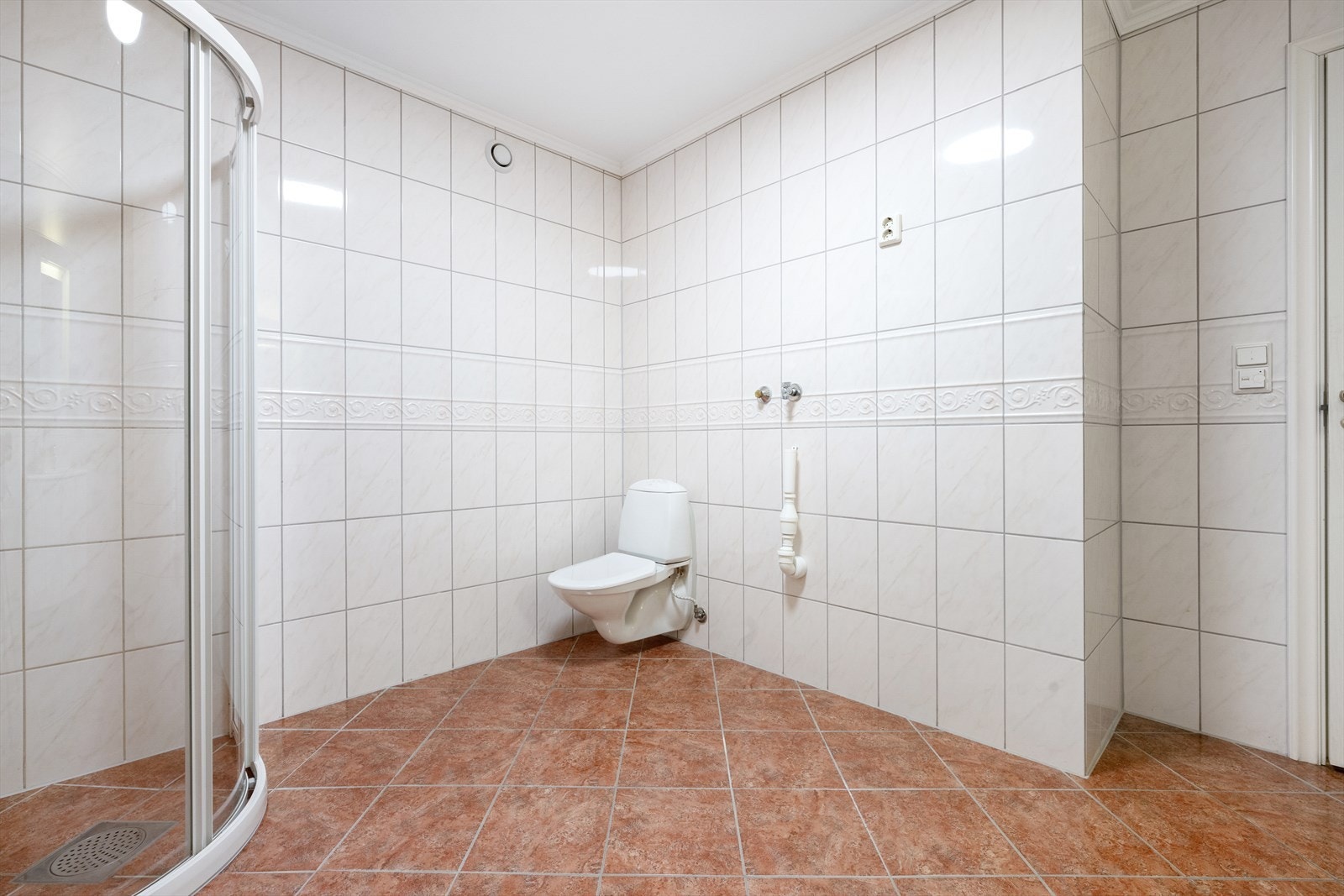 Badet har vegghengt toalett og opplegg for vaskemaskin. Galleribilde