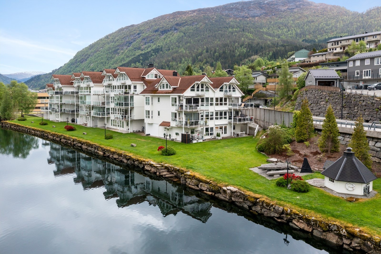 Bygget ligg fint til ved Jølstra, med felles grøntareal og grillhytte for bebuarane. Galleribilde