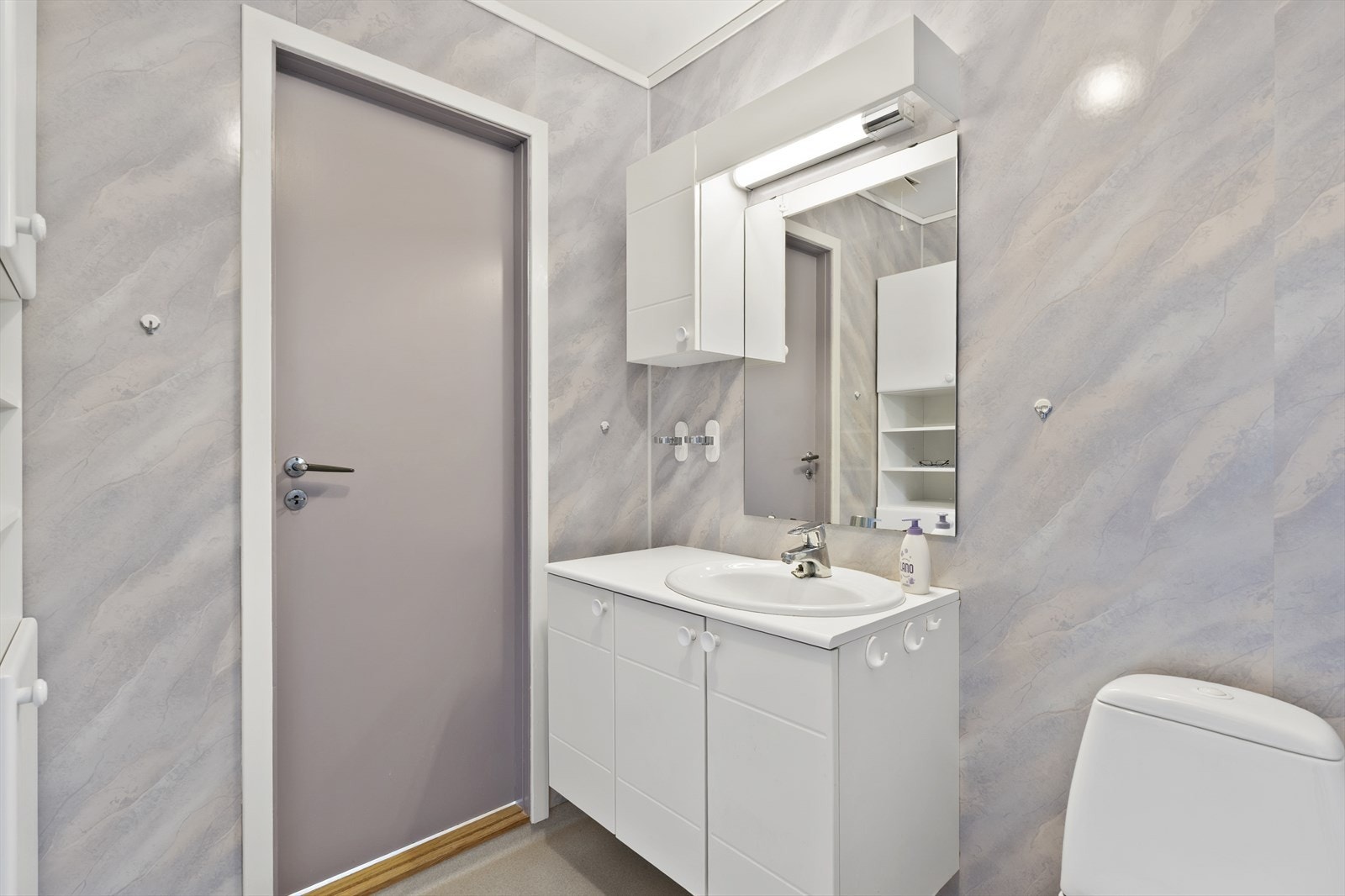 Badet har baderomsplater på veggene, servantmøbel og dusjhjørne. Galleribilde