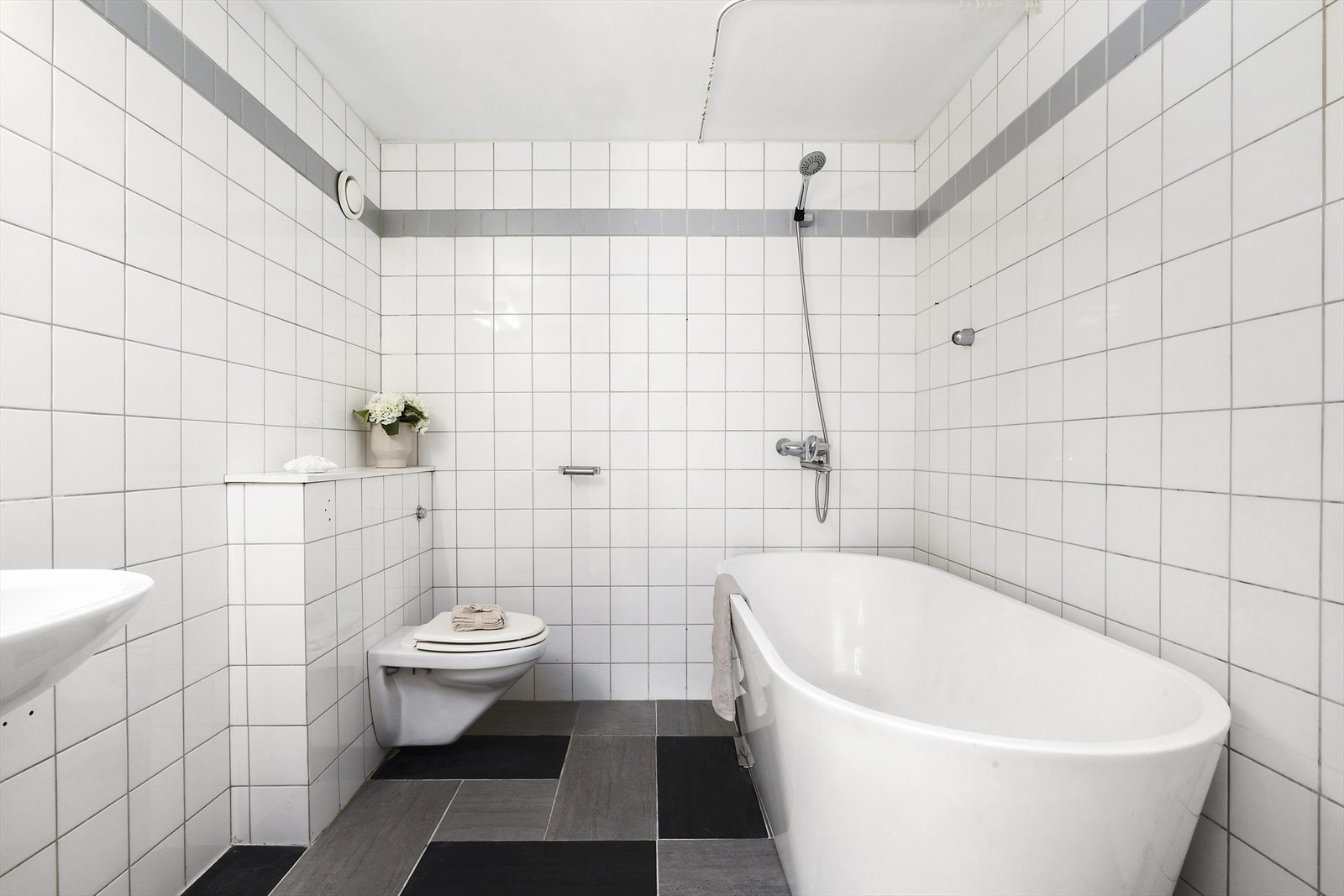 Flislagt baderom av god størrelse med vannbåren gulvvarme og plass til vaskemaskin. Galleribilde