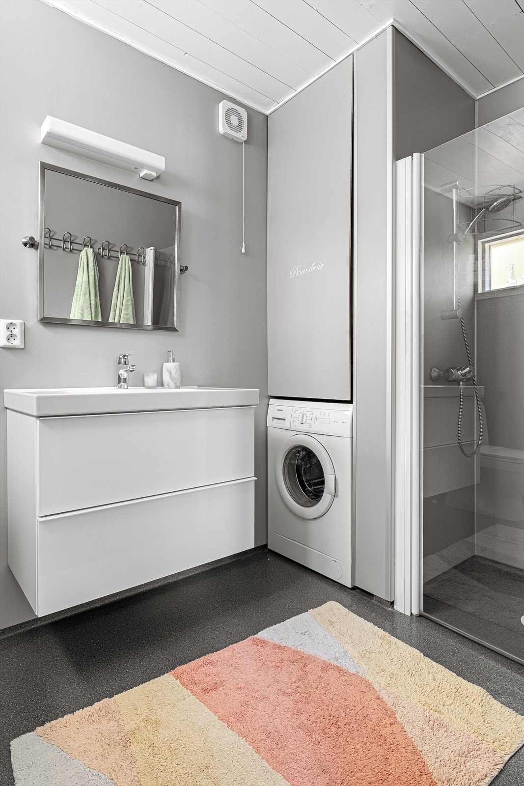 Baderomsinnredning med dusjhjørne, wc, opplegg til vaskemaskin og servant med underskap. Galleribilde