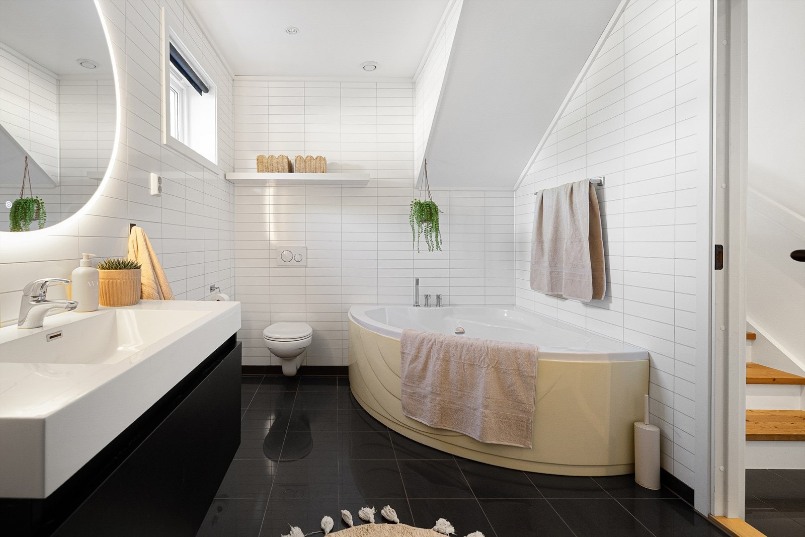 Badet på 10 kvm har både badekar og nedsenket dusjsone i samme lekre utforming som badet ovenpå. Galleribilde