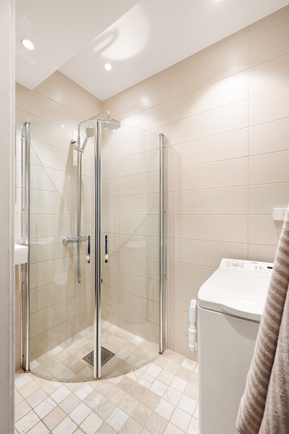 Badet har dusjhjørne med inn-/utadslående dører i herdet glass. Galleribilde