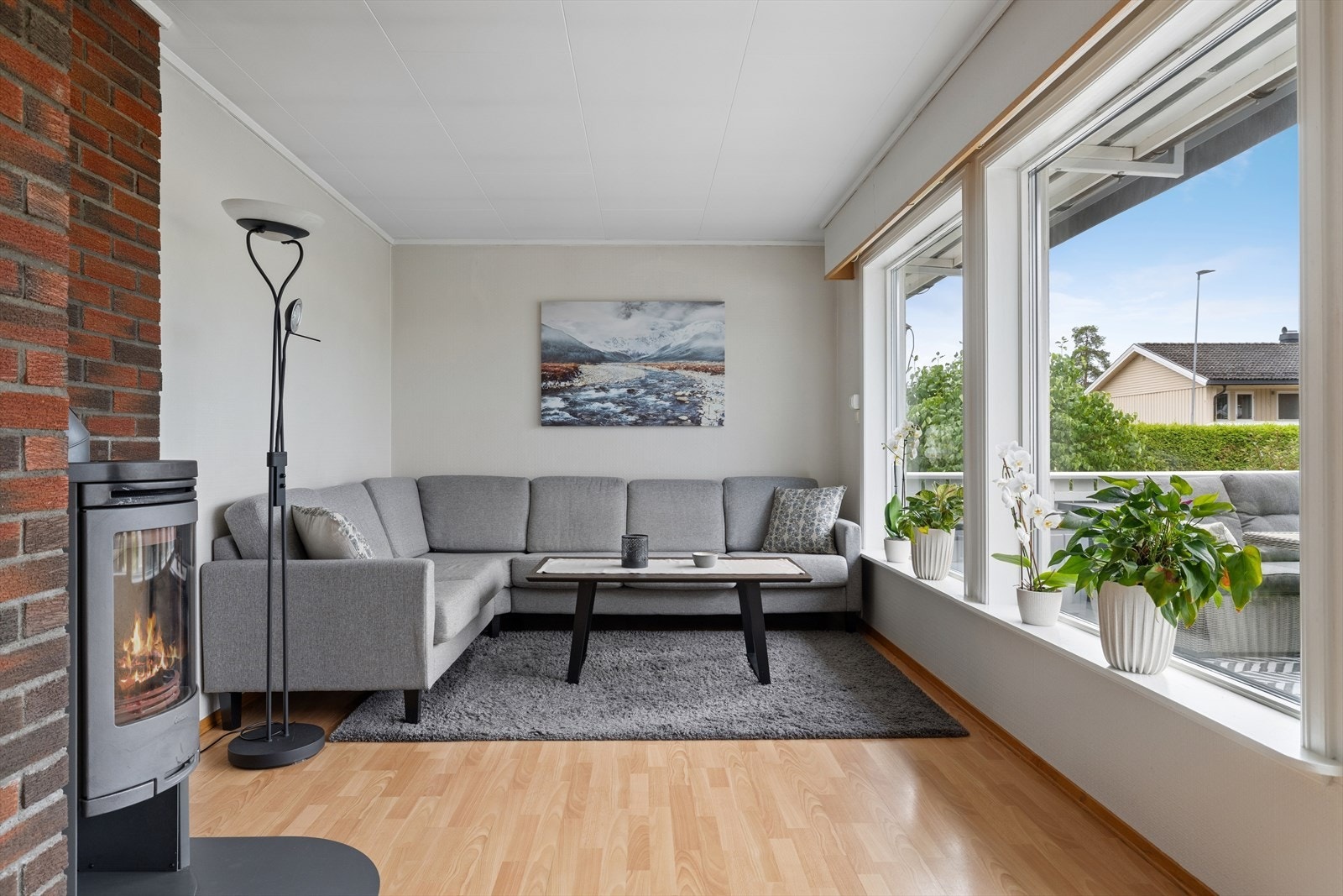Stuens utforming gir god plass til et romslig sofahjørne, mens den vedfyrte peisen skaper en lun og behagelig atmosfære på kjølige dager. . Galleribilde