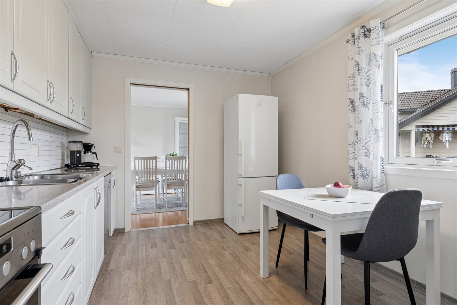 Kjøkkenets romslige utforming gir plass til et hyggelig frokostbord, hvor man kan nyte morgenkaffen ved vinduet. Galleribilde