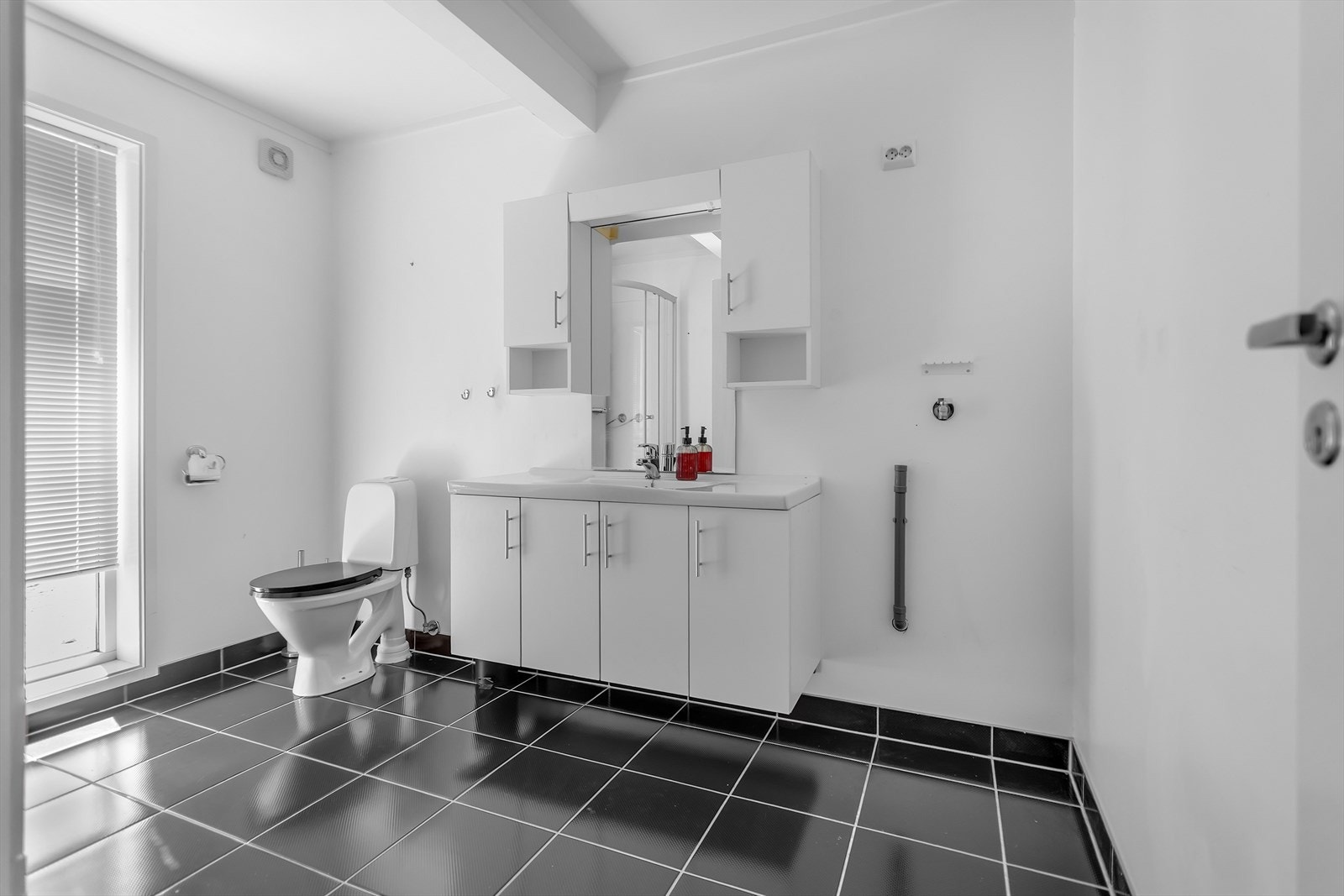 Stilrent og pent baderom som er godt utnyttet og funksjonelt innredet. Badet er utstyrt med dusjkabinett, servant med både over- og underskap for praktisk oppbevaring, toalett og opplegg til vaskemaskin. Galleribilde