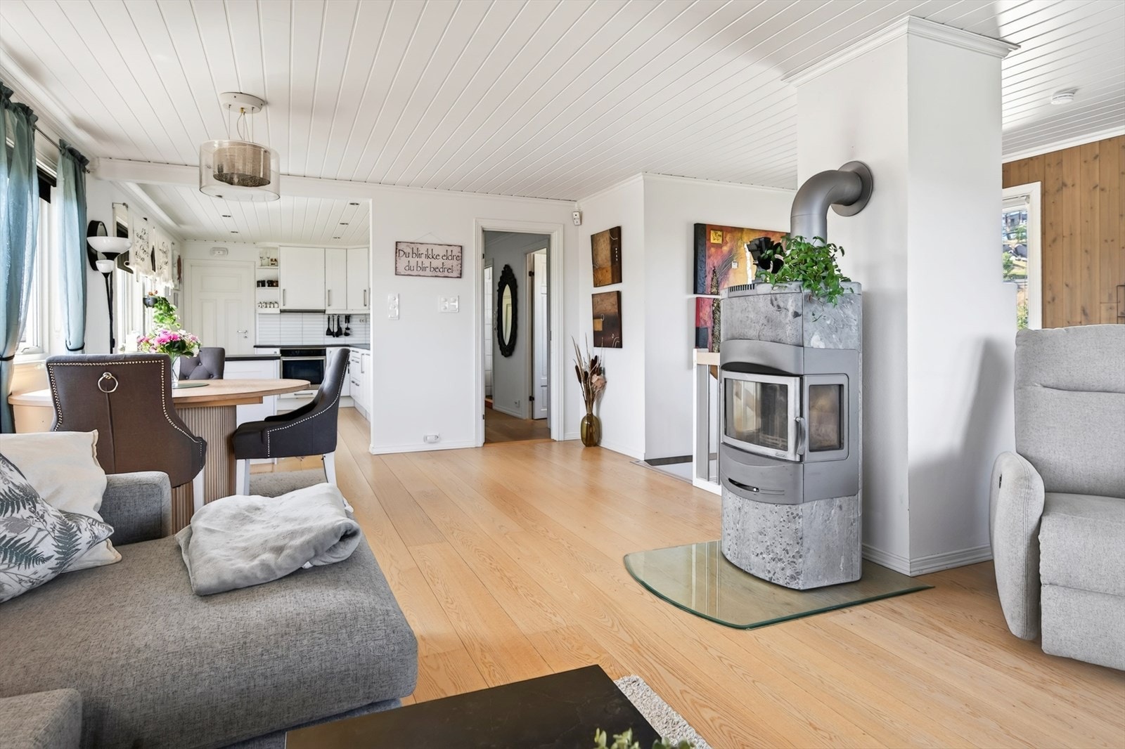 Stua fremstår lys og trivelig med gode lysforhold, hvitmalte vegger og eikeparkett på gulvet. Galleribilde