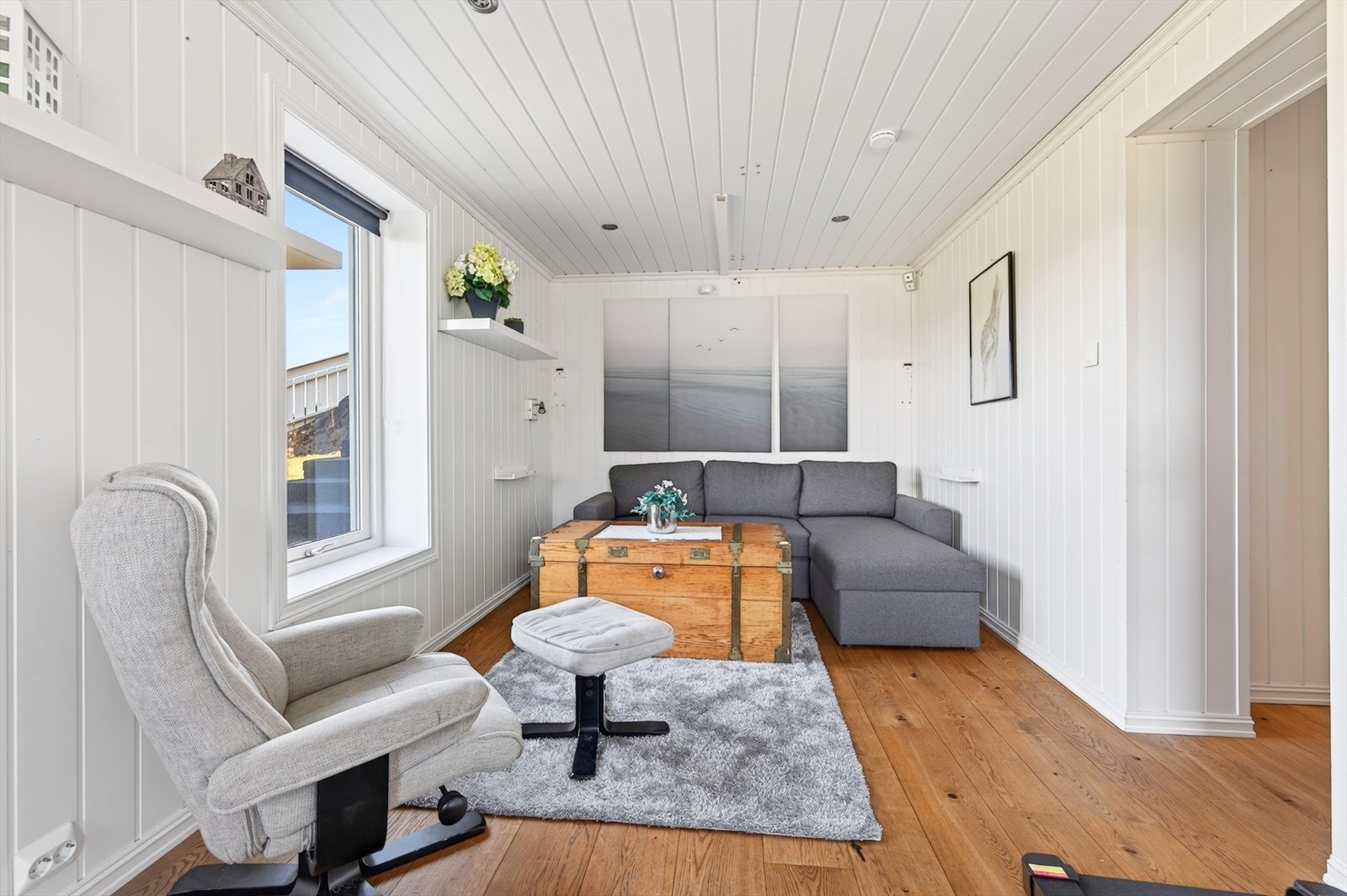 Lyst og luftig rom som i dag er innredet med laminat på gulv, og panelplater på vegg. Galleribilde