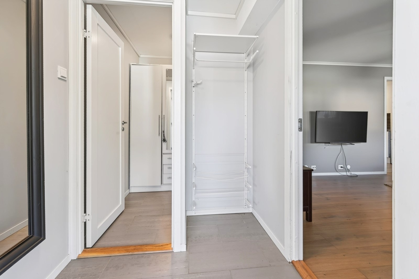 Vi beveger oss inn i utleiedelen av boligen, hvor vi møtes av en lys gang, med god oppbevaringsplass og fliselagt gulv. Galleribilde