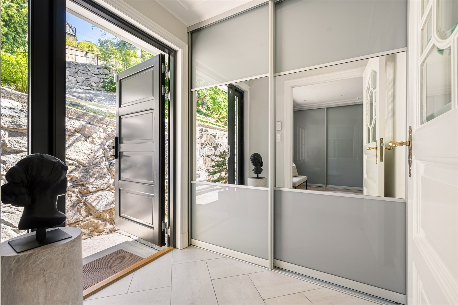 Entrè med praktisk skyvedørsgarderobe, her er det plass til oppbevaring av sko og yttertøy. Det er varmekabler i gulv. Galleribilde