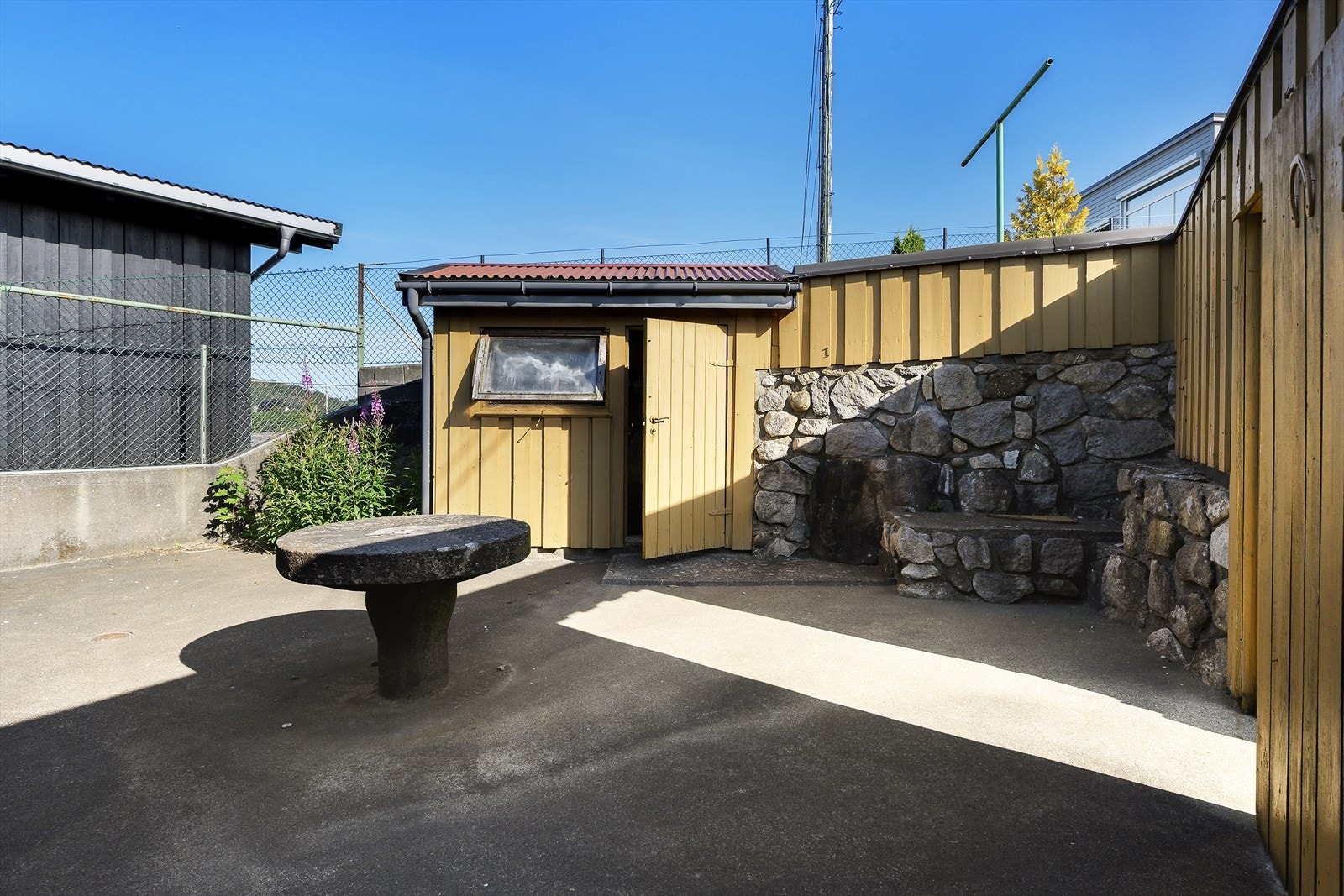 Skjermet uteplass med frittstående bod. Galleribilde