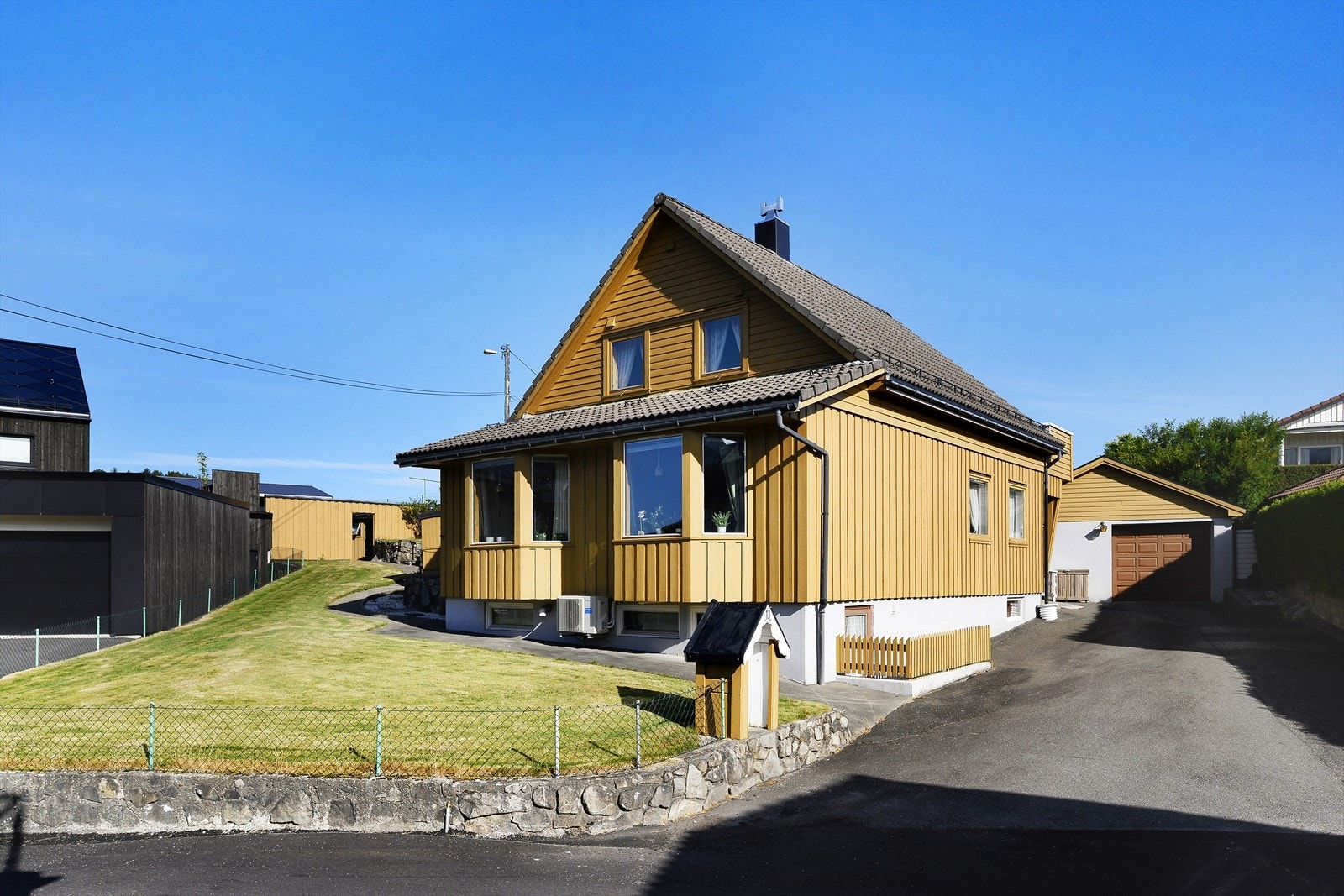 Asfaltert innkjørsel fører til en dobbelgarasje på 32 m². God parkering på egen tomt. Galleribilde