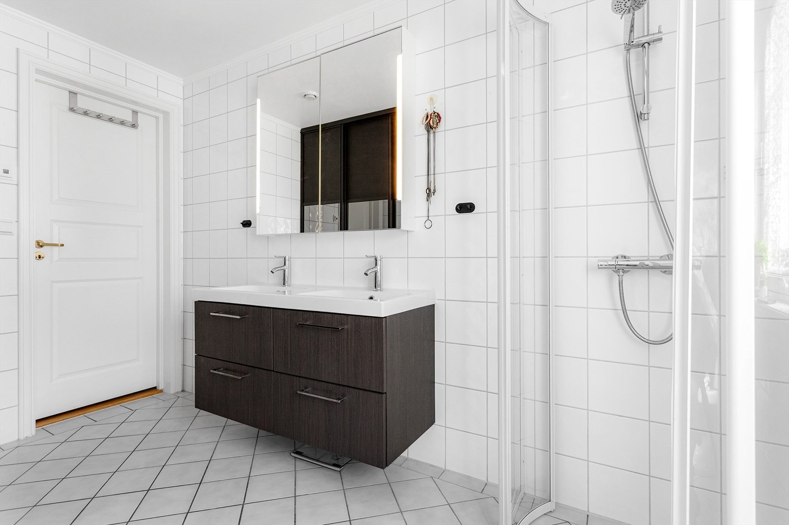Badet har gulvvarme, dusjhjørne og to servanter i baderomsinnredningen. Galleribilde