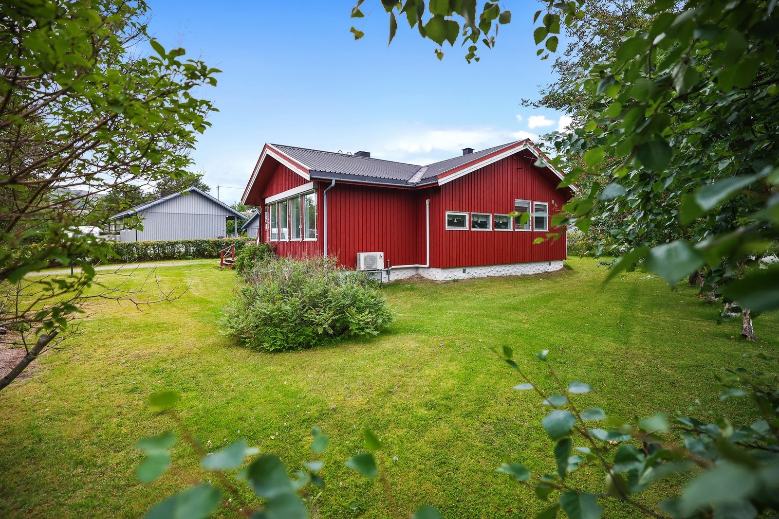 Tomten er opparbeidet med plenarealer og diverse beplantning. Galleribilde