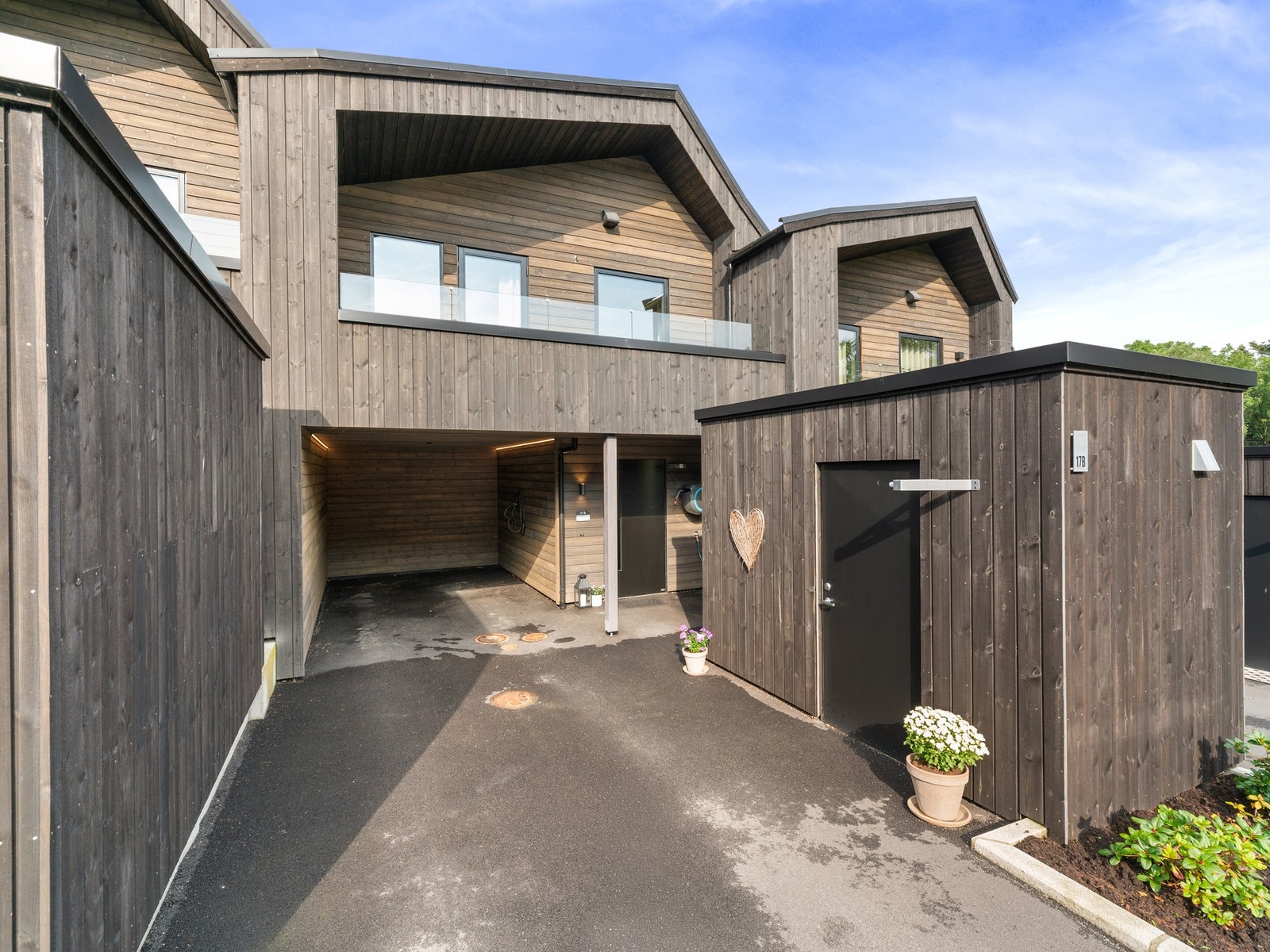 Carport med el bil lader, parkeringsplass og sportsbod. Galleribilde