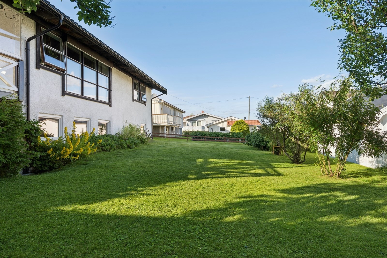Hagen er pent opparbeidet med plen og diverse beplantning. Galleribilde