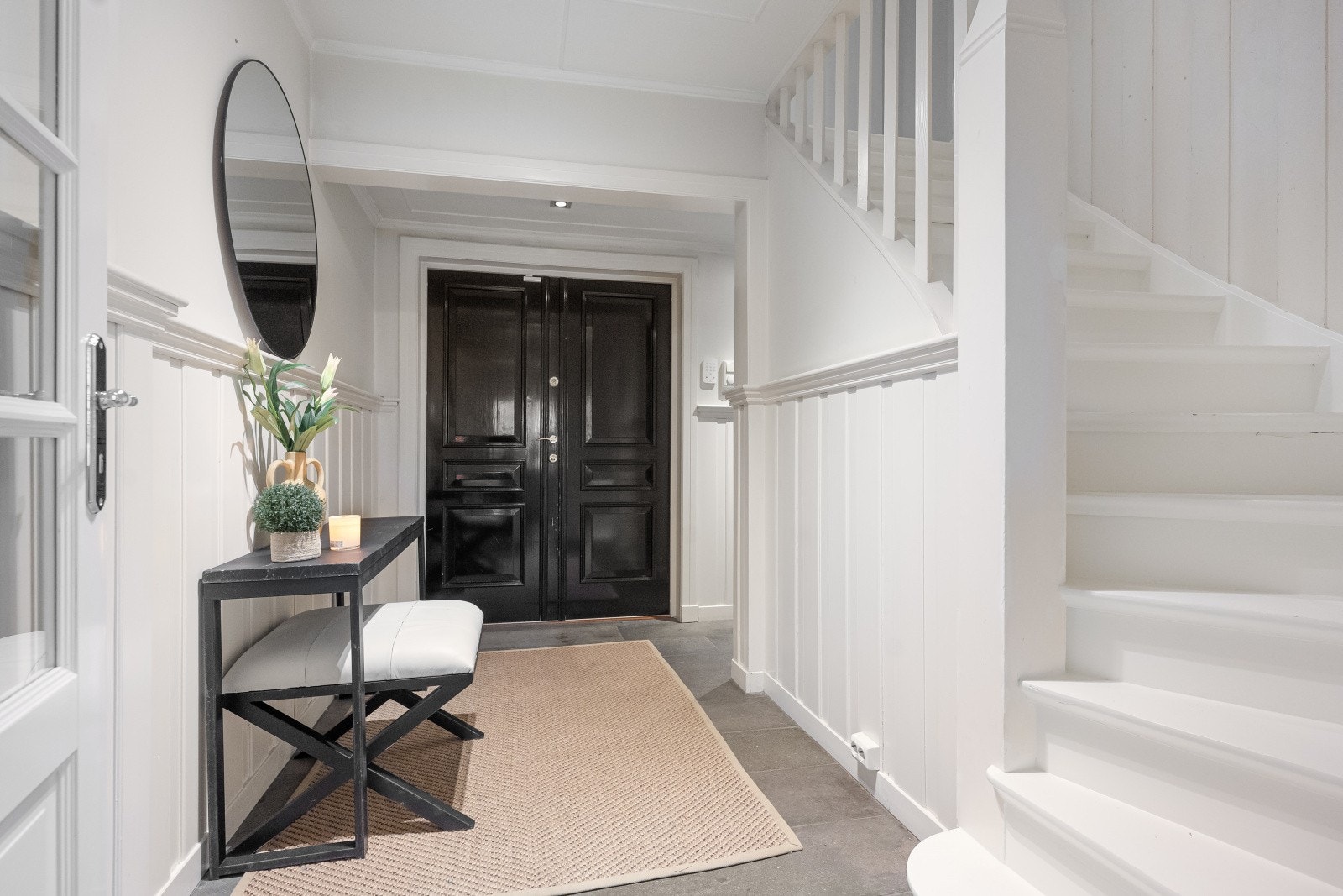 Velkommen inn! En romslig hall ønsker deg velkommen og skaper en naturlig forbindelse mellom første etasje og boligens øvrige plan. Trappen leder elegant videre gjennom hjemmet. Galleribilde