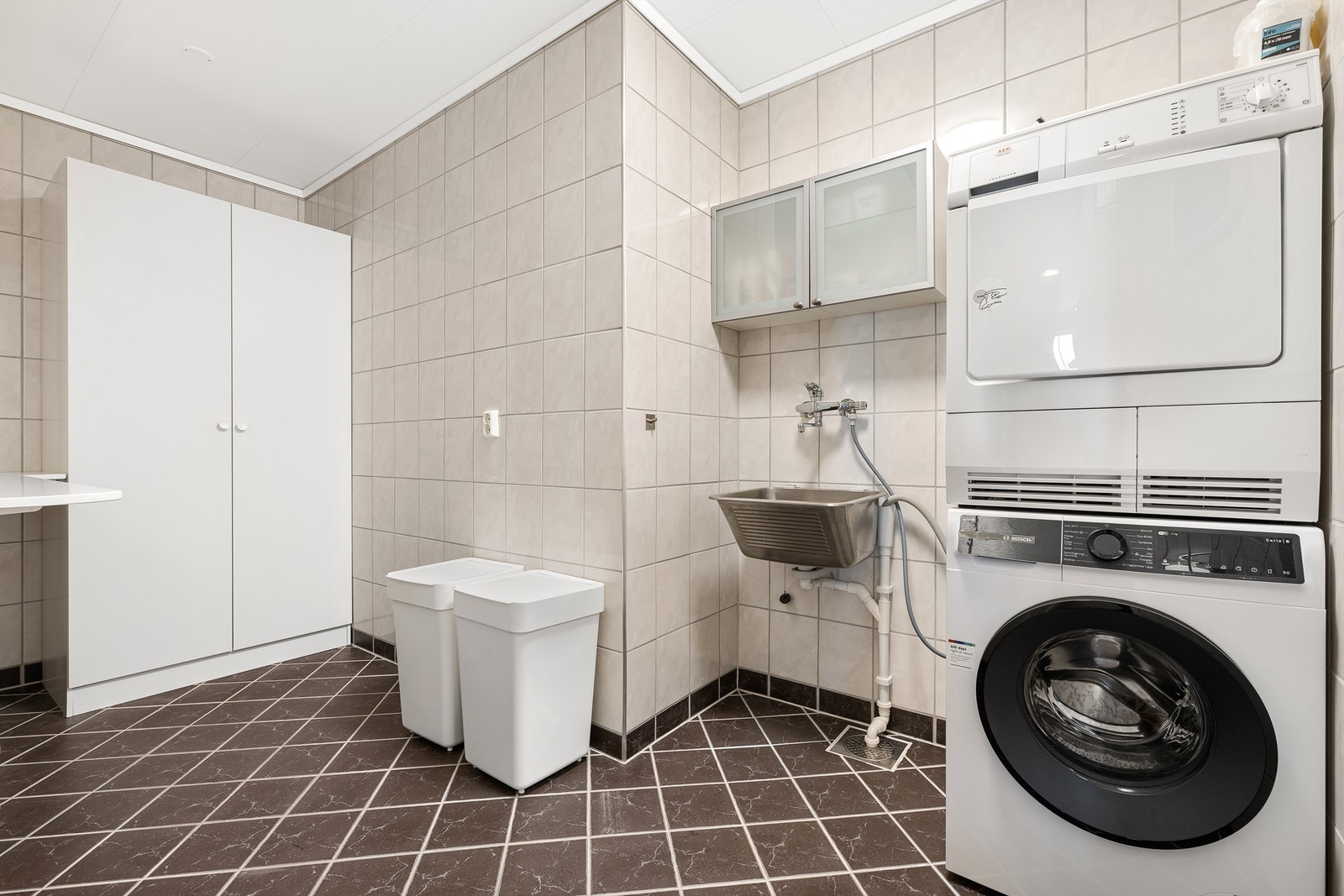 Separat vaskerom med flislagt gulv, gulvvarme og opplegg for vaskemaskin. Galleribilde