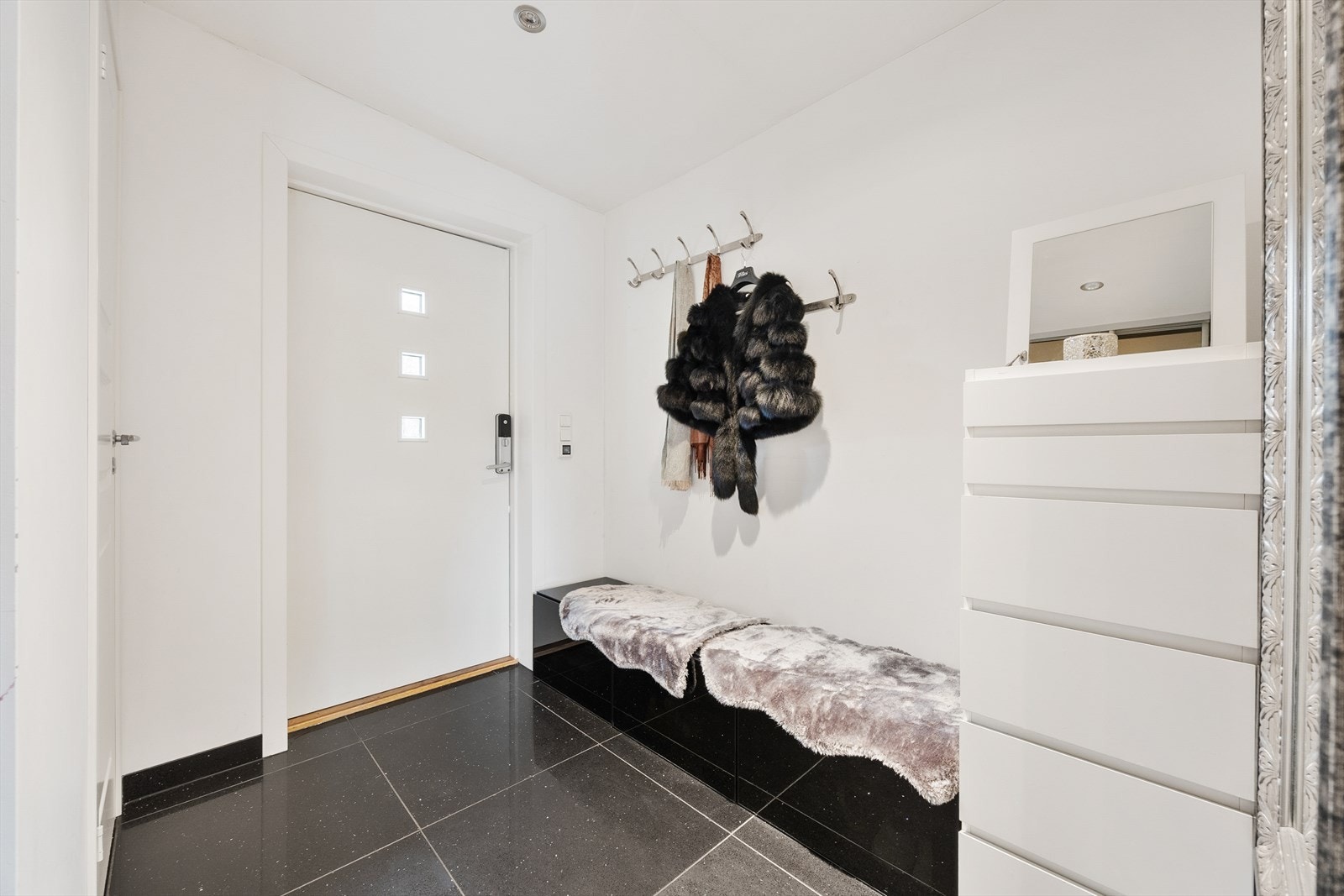 Fra hovedinngangen kommer man inn i en lys og romslig entré med flislagte gulvflater. Galleribilde