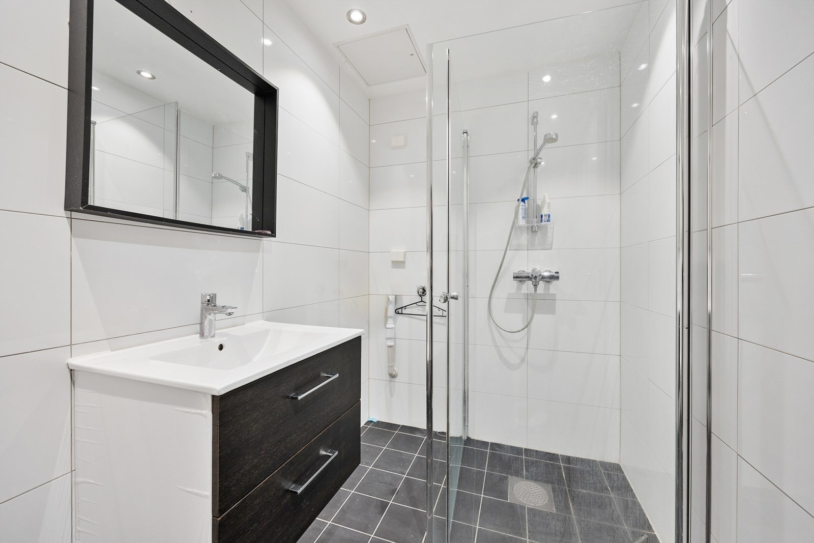 Badet fra 2000 er innredet med porselenservant med skuffeinnredning, vegghengt toalett og dusjsone med innfellbare glassdører. Galleribilde