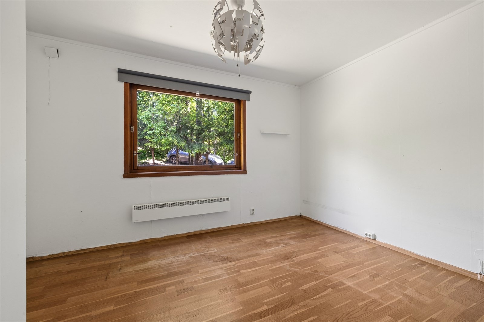 Et annet soverom i første etasje med parkettgulv og vindu med fint utsyn til hagen. Galleribilde