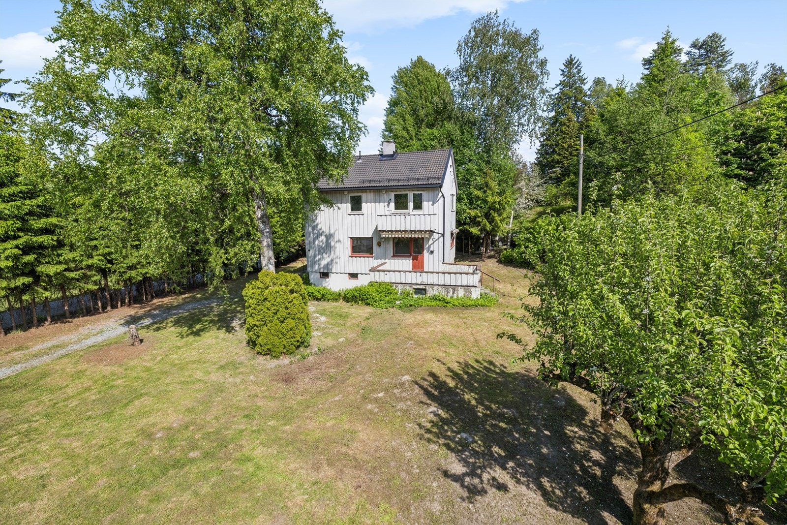 Tomten er opparbeidet med gressplen, beplantning og trær, og har en gruslagt innkjørsel og gårdsplass. Galleribilde