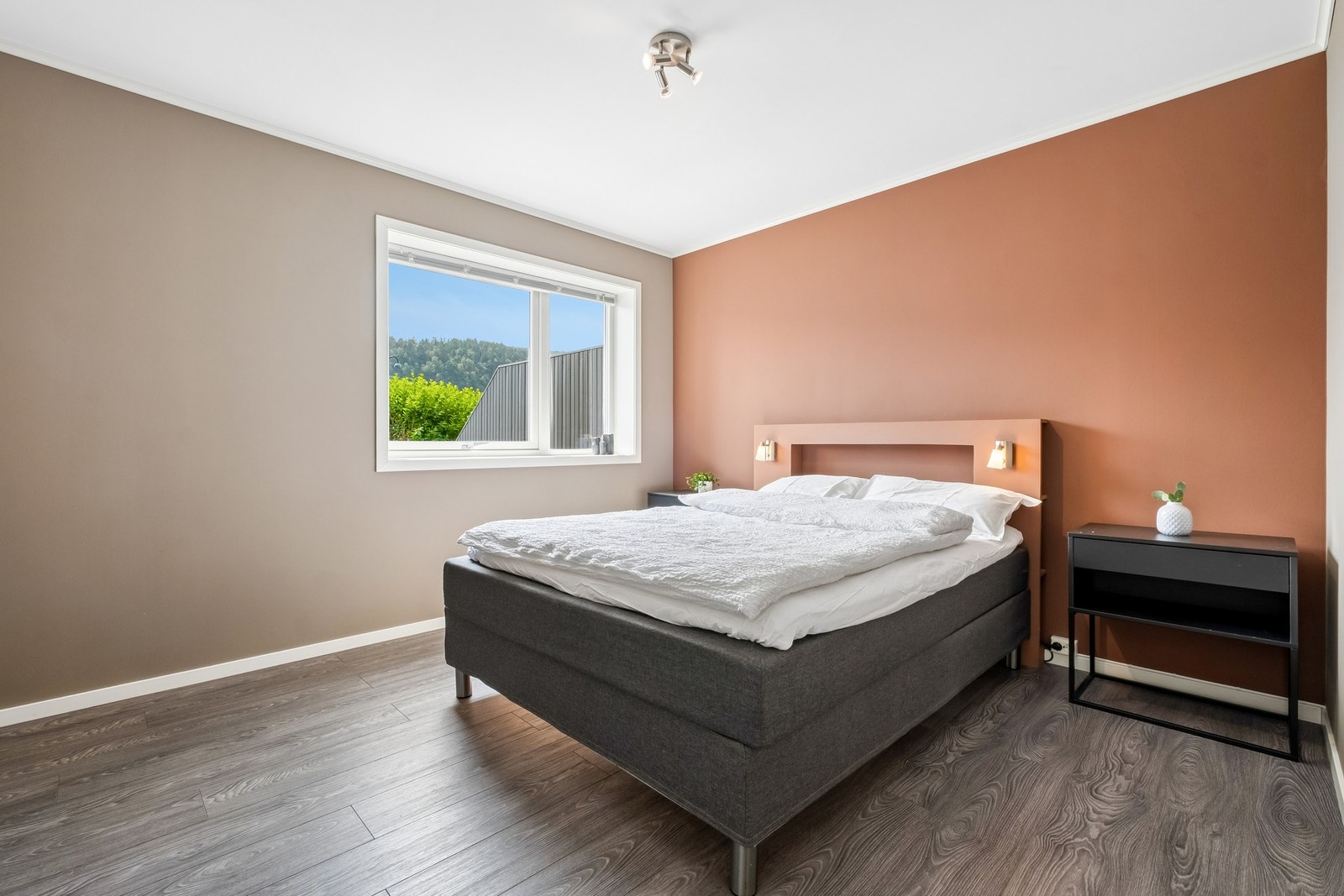Soverommet har en kombinasjon av beige og terrakottafargede vegger. Galleribilde