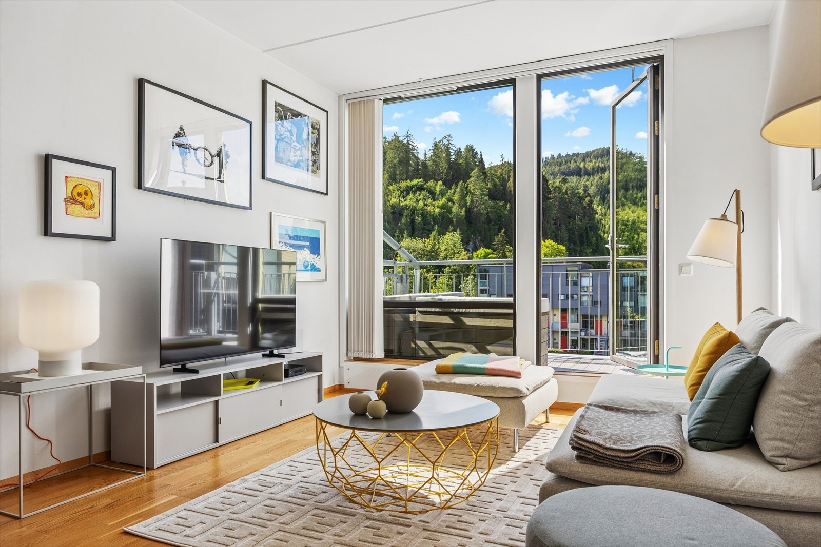 De store vindusflatene i kombinasjon med de lysmalte overflatene gjør oppholdsrommet lyst og innbydende. Galleribilde