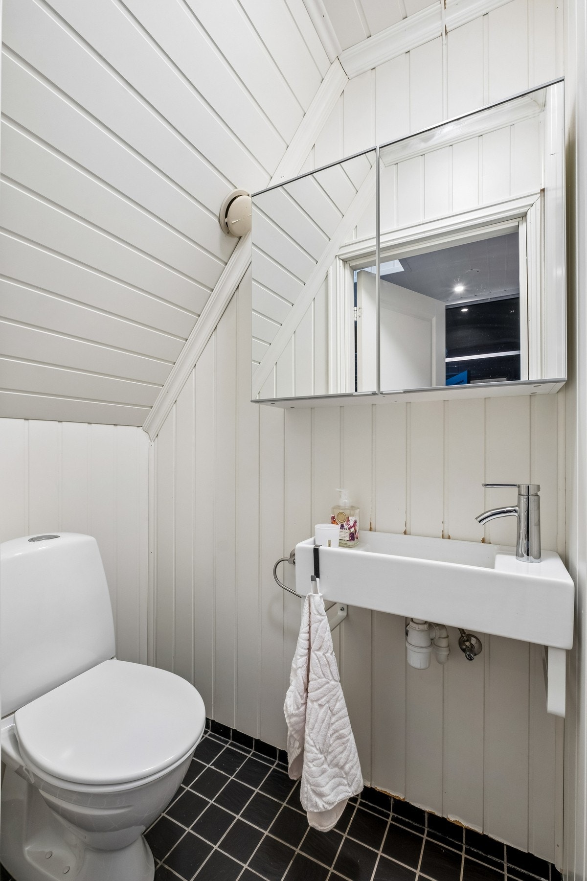 Lyst og funksjonelt toalettrom med wc, speilskap og servant. Galleribilde