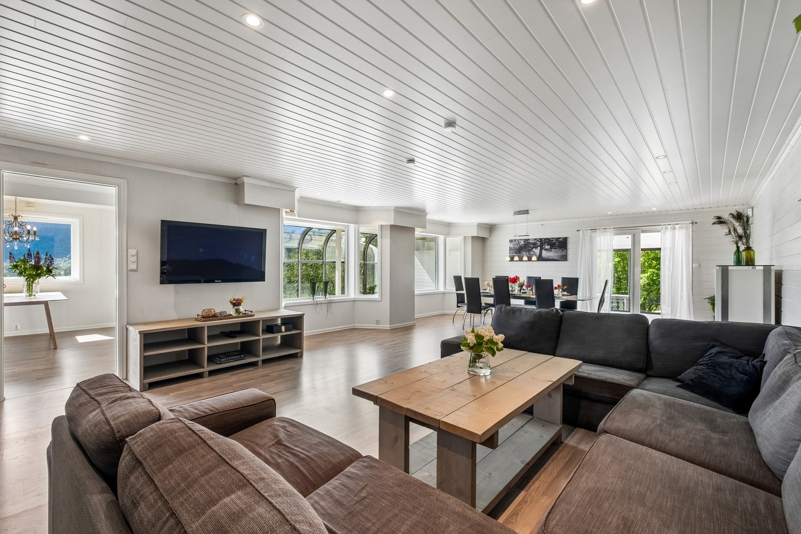 Stuen har store vinduer mot sør, lyse overflater og åpen løsning. Her er det god kontakt mellom rommene og lett tilgang til terrasse via skyvedør. Galleribilde