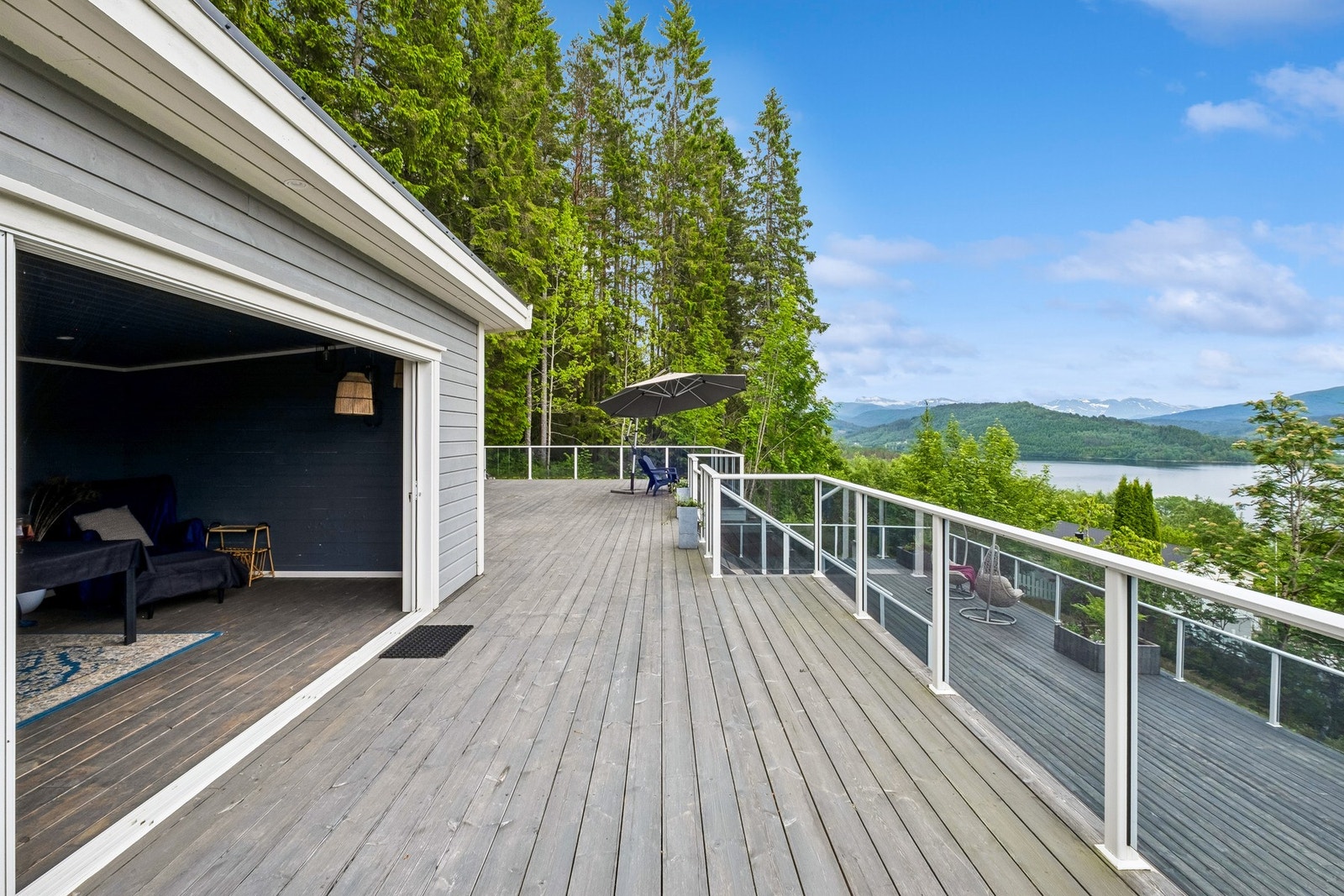 Hagestue og stor terrasse med glassrekkverk og nydelig utsikt Galleribilde
