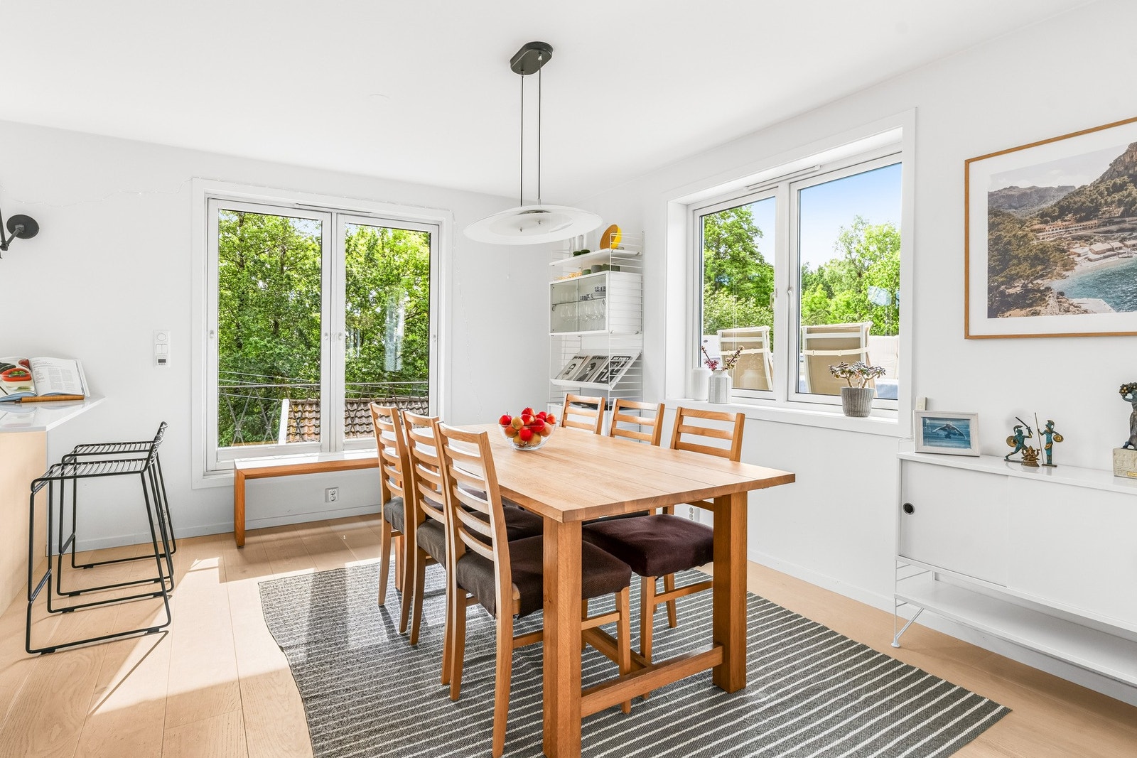 Spisestuen gir rom for store selskaper og langbord. Vinduer mot sydvest, sydøst og gjennomgående lys fra stuen. Smijernsdetalj på fransk balkong. Galleribilde