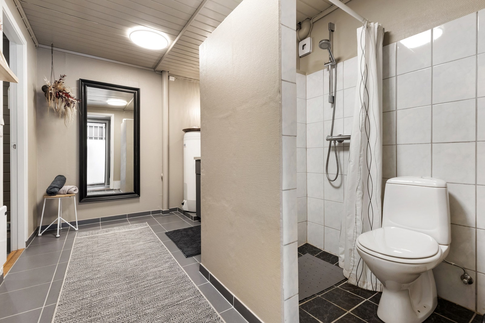 Badet har gulvstående toalett og dusjnisje. Galleribilde