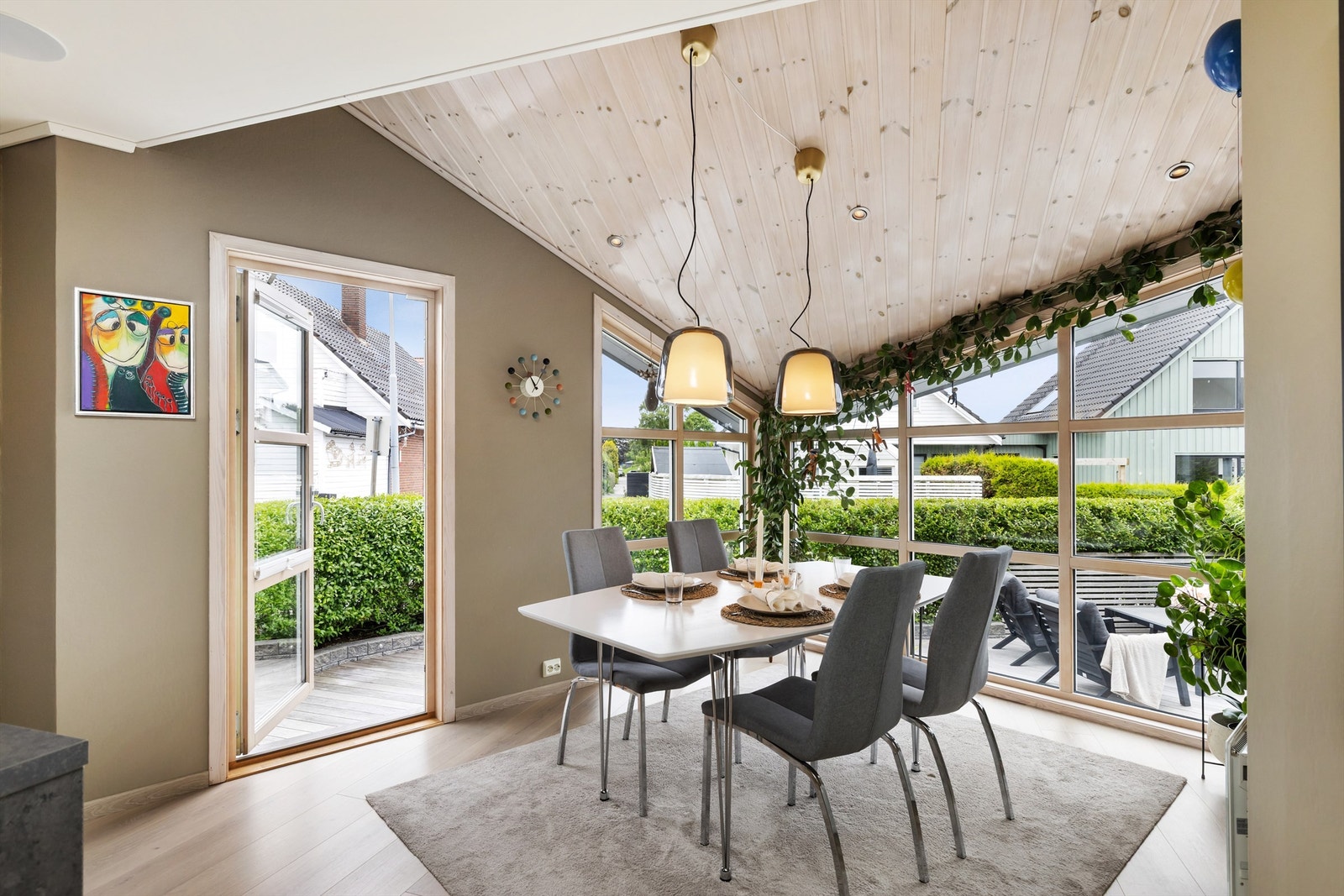 Store vindusflater gir rikelig med naturlig lys til spiseplassen. Her er det utgang til terrasse og uteplass på fremsiden av boligen. Galleribilde