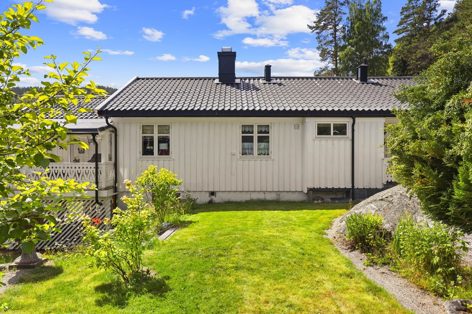 Uteområde ved våningshuset med plen og hyggelig beplantning. Galleribilde
