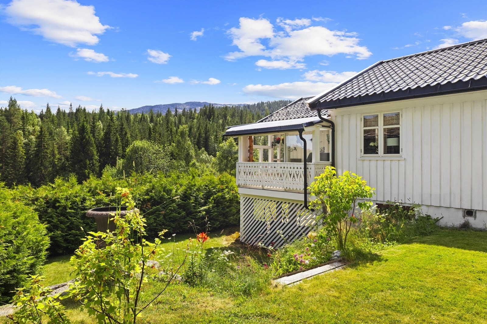 Fra hagen er det utsikt mot de omkringliggende skogkledde åsene. Galleribilde