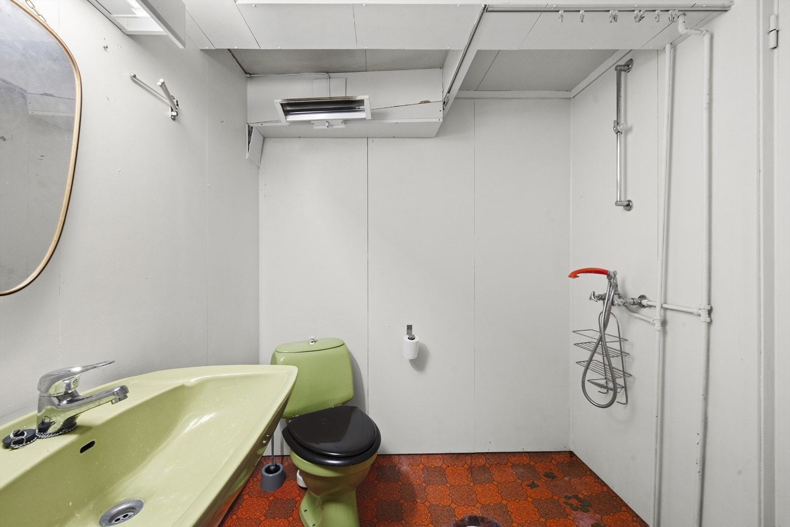 Badet i underetasjen har eldre standard med vinylbelegg på gulv og åpen dusjløsning. Galleribilde