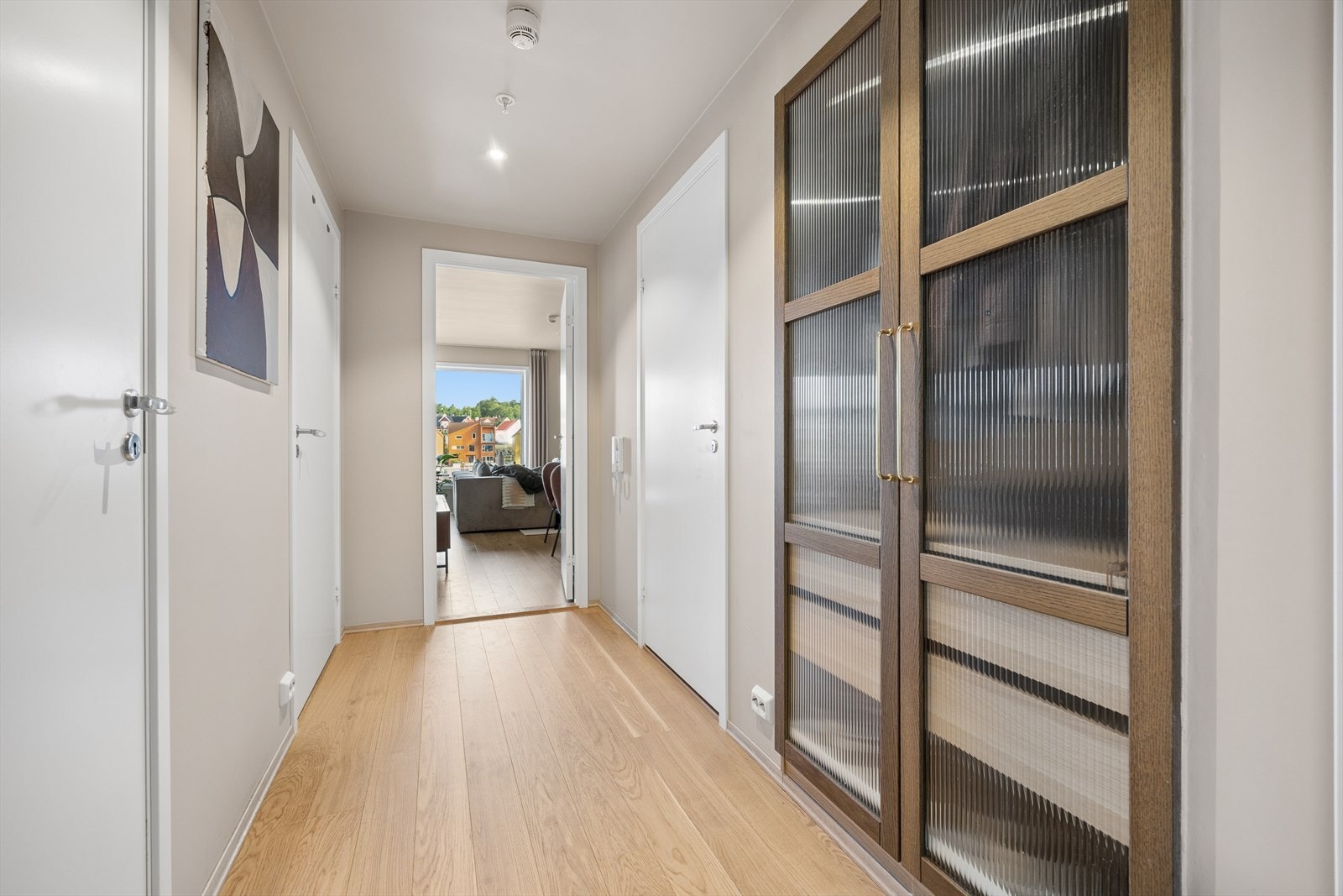 Lys og innbydende entré, med et lekkert integrert garderobeskap med glassfronter. Galleribilde