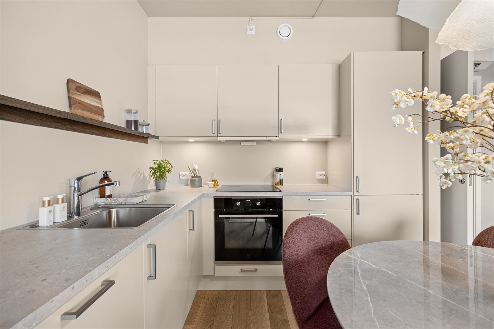 Et svært stilrent kjøkken med alle hvitevarer integrert: stekeovn, platetopp, oppvaskmaskin og kjøl/fryseskap. Galleribilde