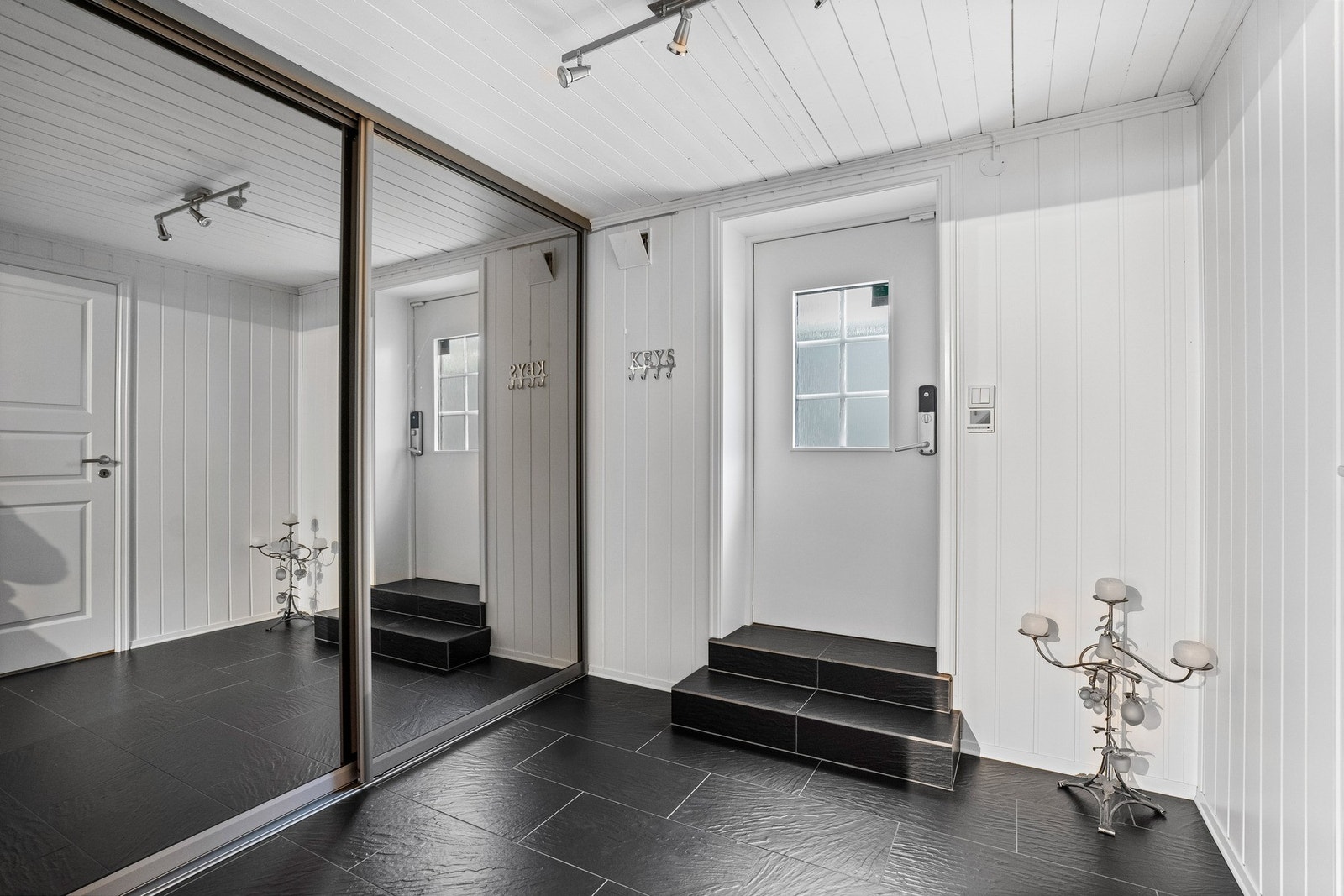 Underetasjen har egen inngang via en flislagt entré med skyvedørsgarderobe. Dette gir mulighet for direkte adkomst til boligen fra begge plan. Galleribilde