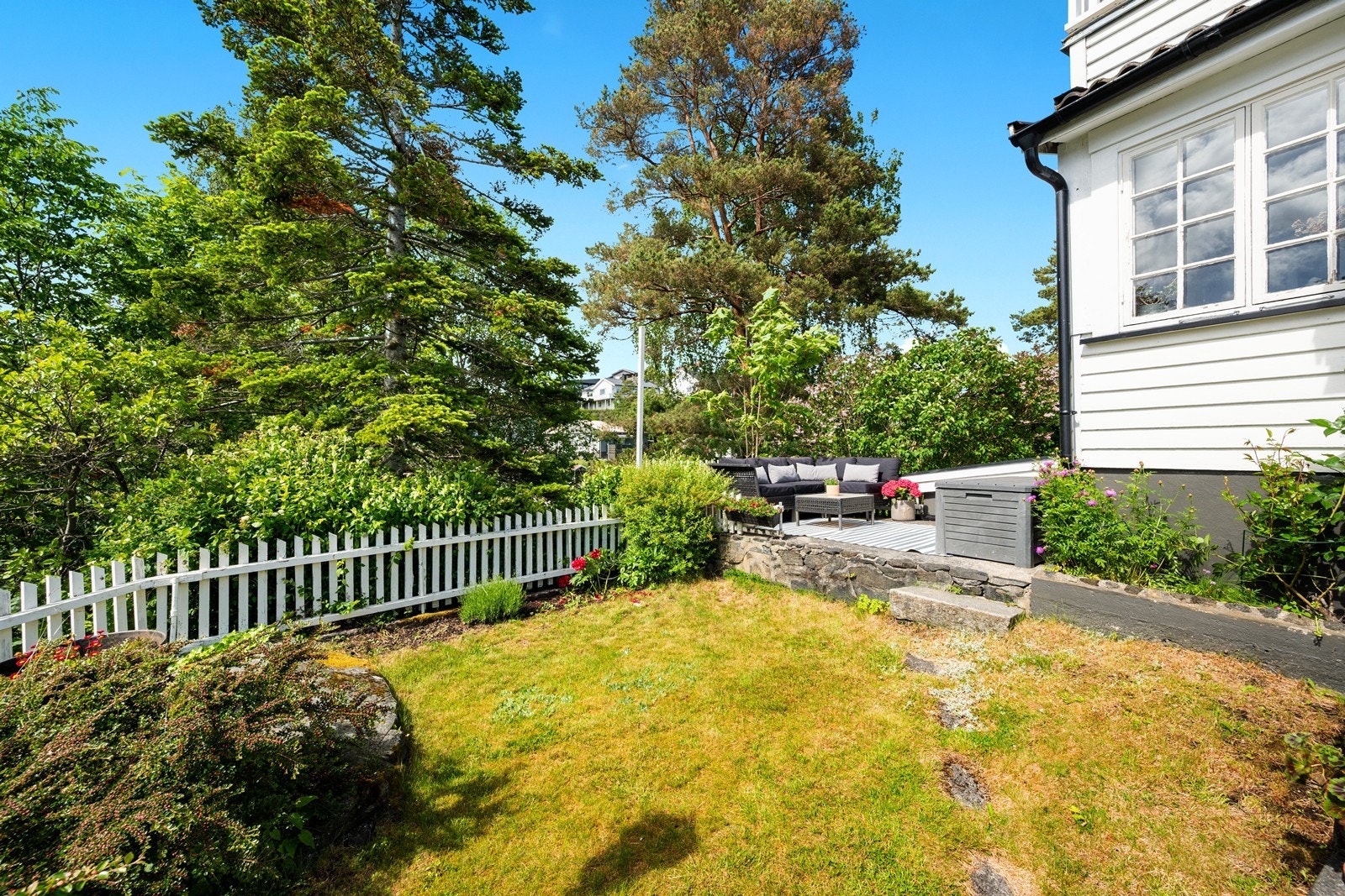Hage og støpt platting på siden av huset. Galleribilde